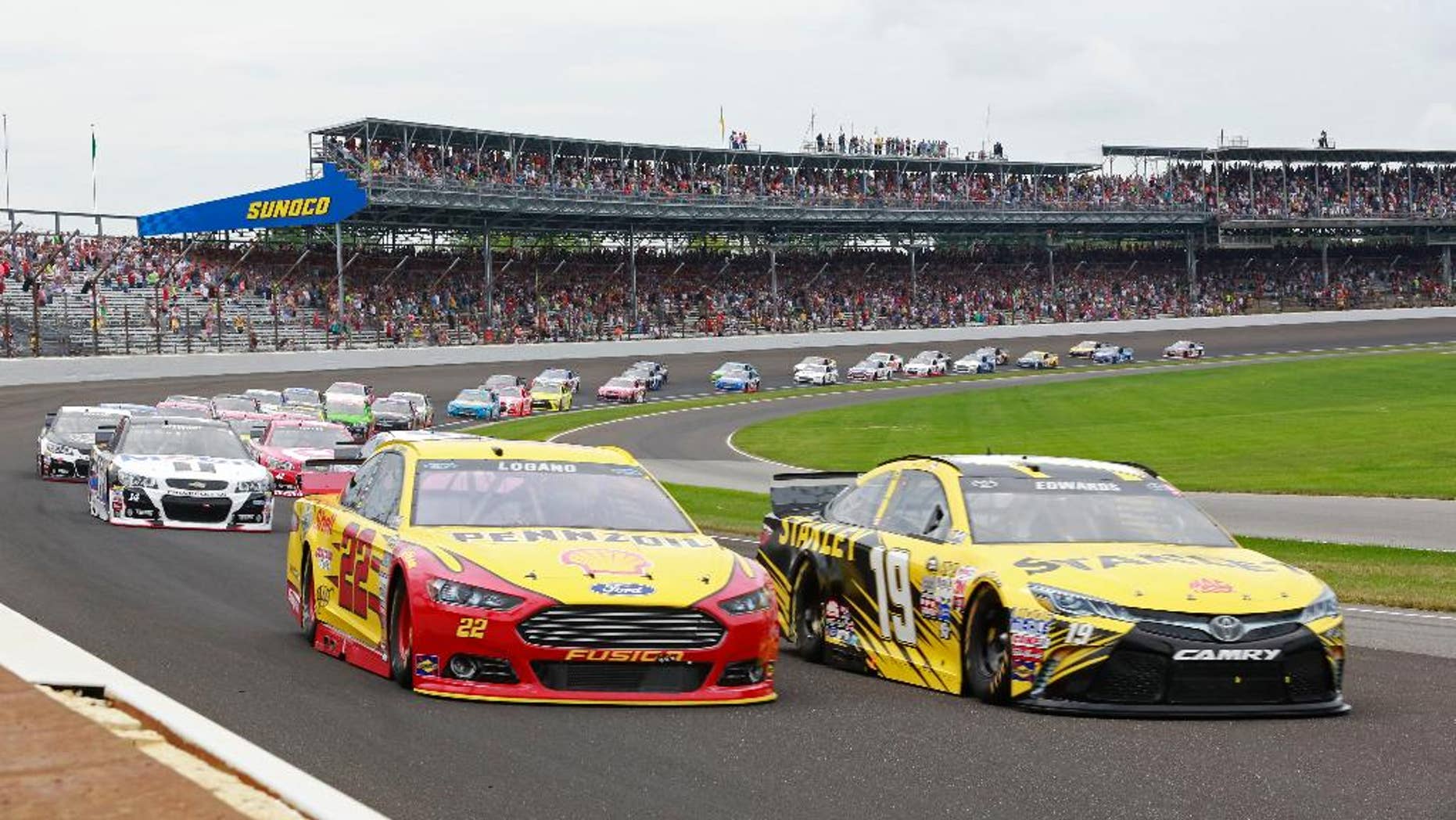July 26, 2015: Carl Edwards (19) and Joey Logano (22) lead the field through the first turn on the start of the NASCAR Brickyard 400 auto race at Indianapolis Motor Speedway in Indianapolis.
