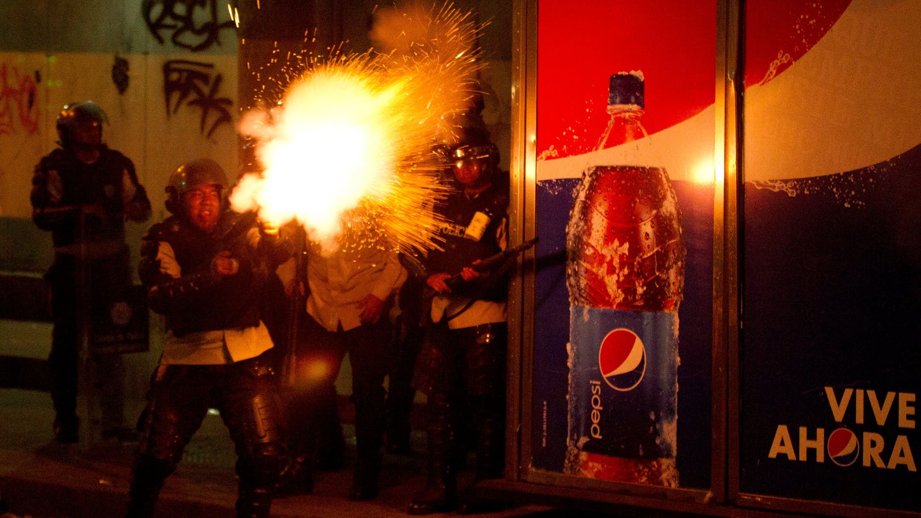 Un policía nacional bolivariano dispara gases lacrimógenos contra manifestantes antigubernamentales en Caracas, Venezuela, el sábado 22 de marzo de 2014. (Foto AP/Esteban Félix)