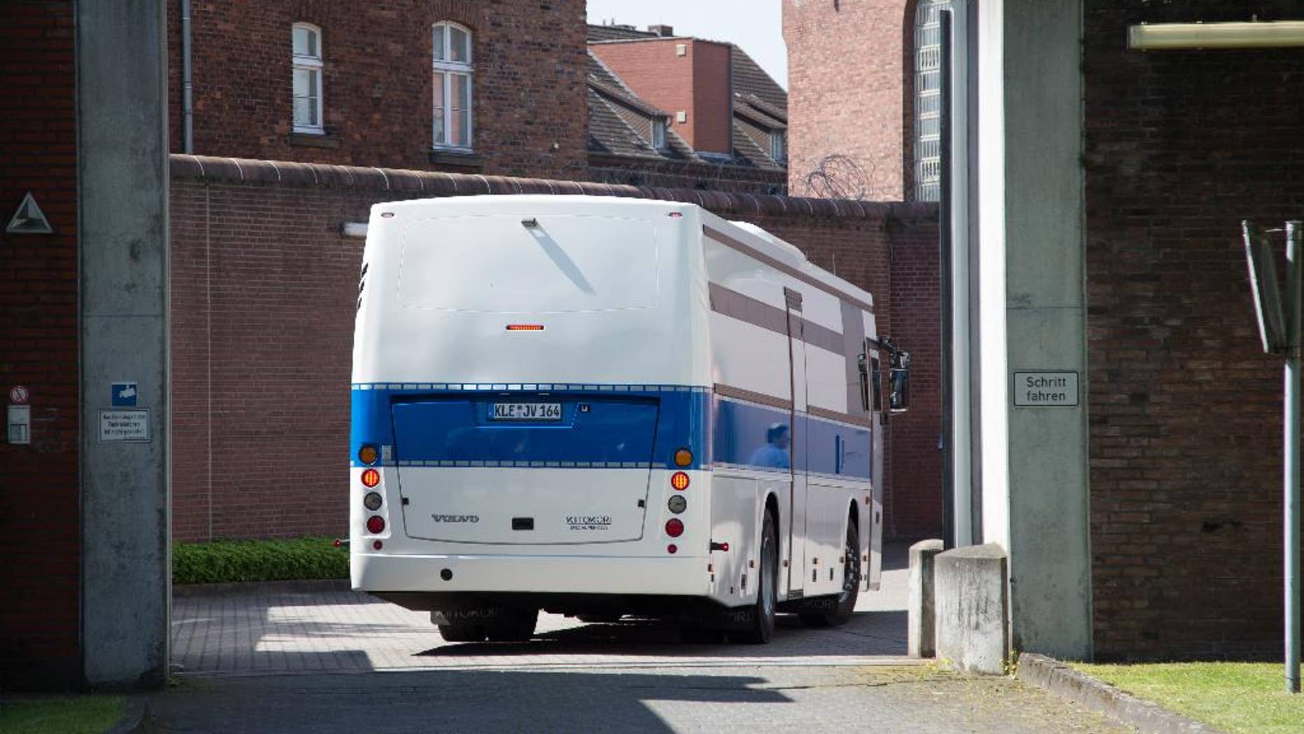 A bus for prisoners drives into the prison in Muenster, western Germany, Thursday, July 7, 2016. More than 500 inmates are being evacuated from the prison after experts said parts of the building were so dilapidated they could collapse any time. (Friso Gentsch/dpa via AP)