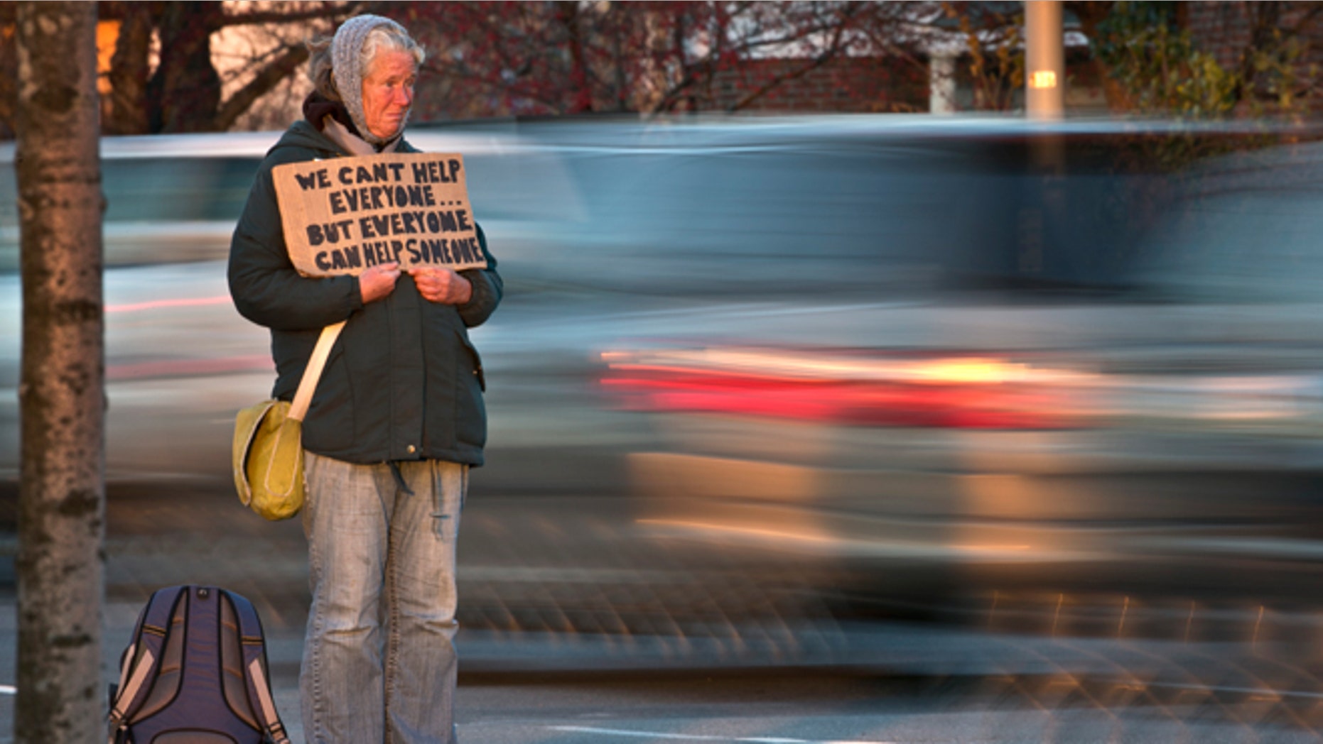 FILE - Nov. 14, 2013: Susan St. Amour, 54, a homeless woman, panhandles during the evening commute in Portland, Maine.