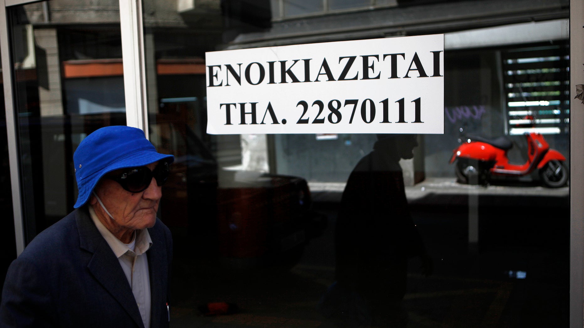 An elderly man passes an empty closed shop with a sign reading in Greek " To rent" in central Nicosia, Cyprus, Tuesday, April 9, 2013. Last month, Cyprus agreed that bondholders, investors and savers with more than 100,000 euros in the country's two largest — and most troubled — banks will take significant losses in exchange for a 10 billion euro ($13 billion) rescue package. (AP Photo/Petros Karadjias)