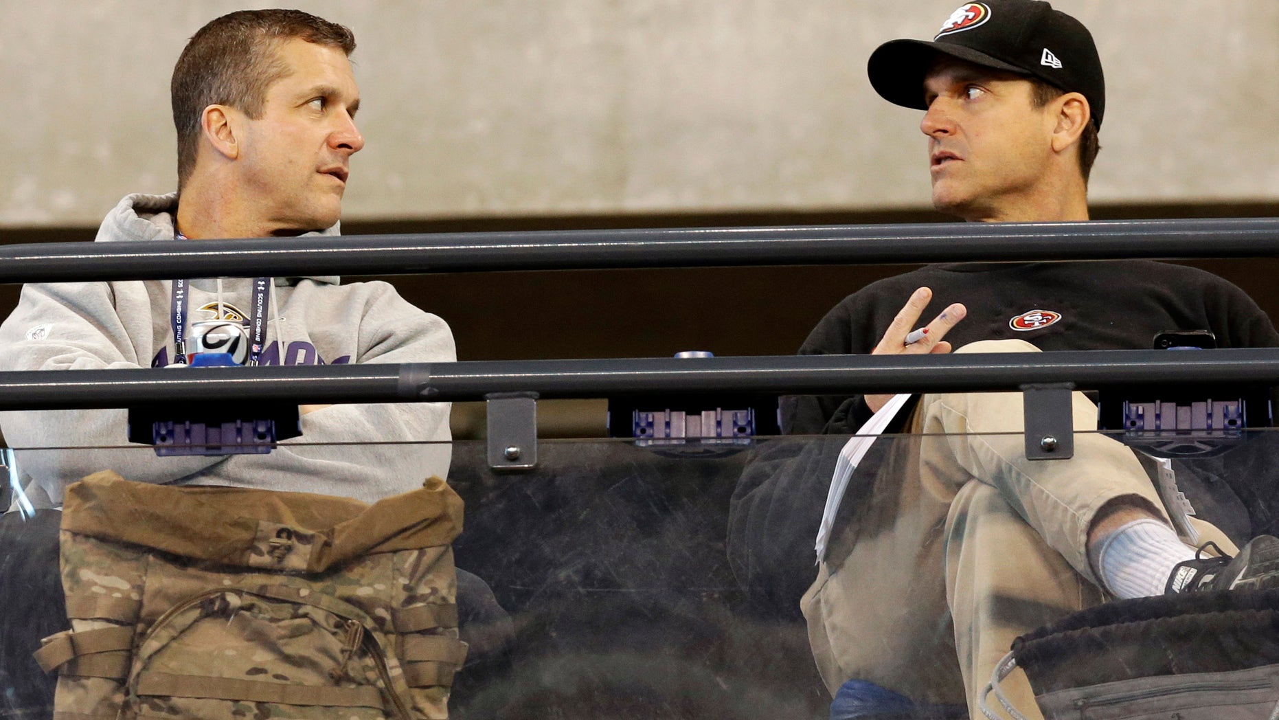 San Francisco 49ers head coach Jim Harbaugh, right, talks with Baltimore Ravens head coach John Harbaugh at the NFL football scouting combine in Indianapolis, Saturday, Feb. 22, 2014. (AP Photo/Nam Y. Huh)