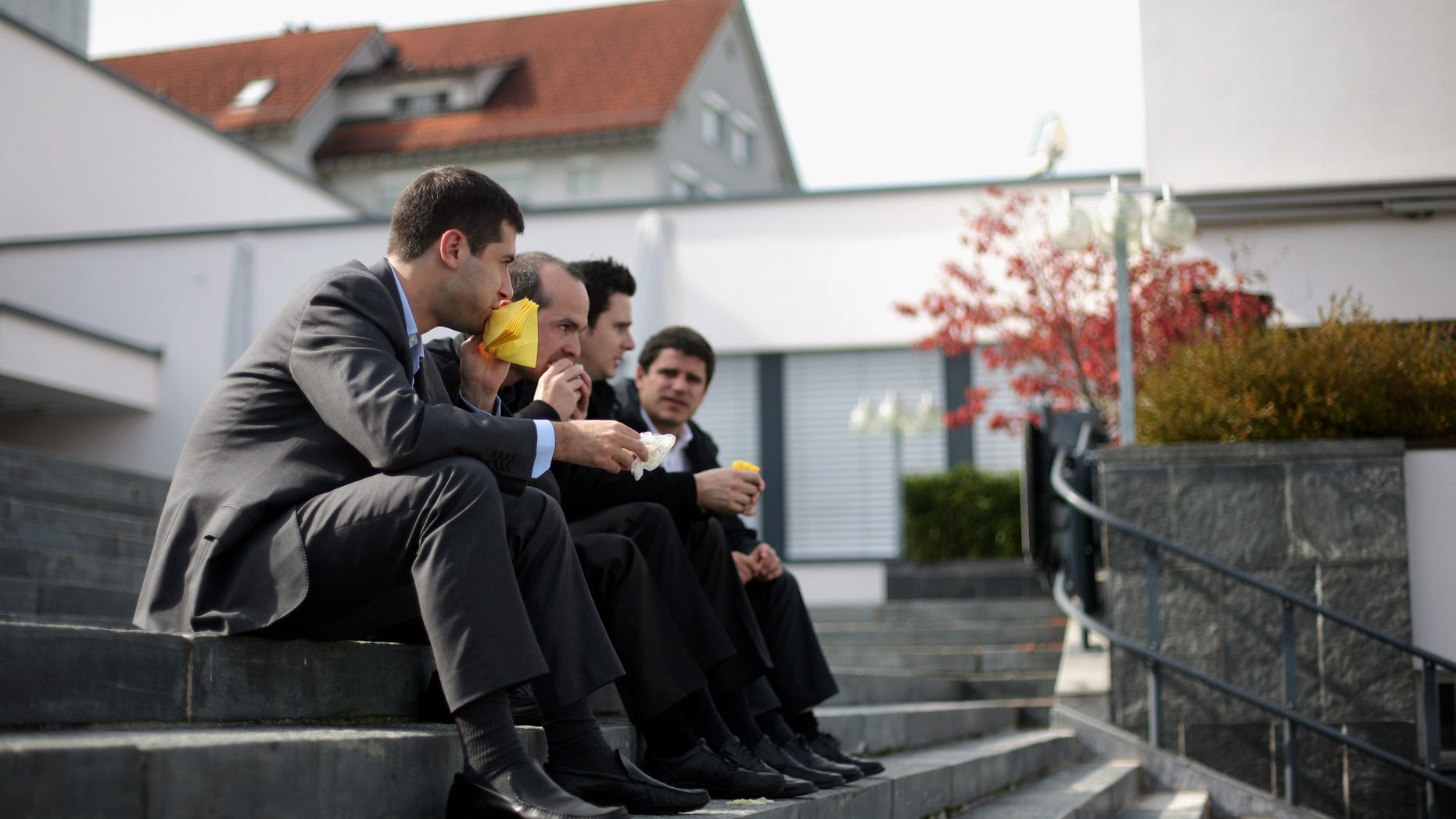 PFAEFFIKON, SWITZERLAND - OCTOBER 06: Four men eat sandwiches during lunch time as they sit on the steps of the village square on October 6, 2009 in Pfaeffikon, Switzerland. Due to lower taxes and less regulation the small Swiss town on the shores of lake Zurich has become a hedge fund hot spot. (Photo by Miguel Villagran/Getty Images)