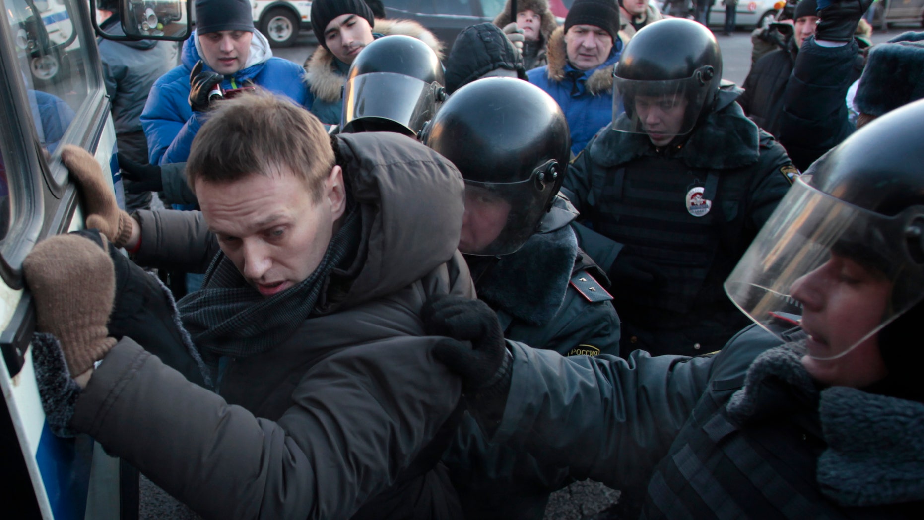 FILE - In this Saturday, Dec. 15, 2012 file photo police officers detain opposition leader Alexei Navalny during an unauthorized rally in Lubyanka Square in Moscow. Navalny, who helped organized the largest anti-Kremlin rallies in Russia's post-Soviet history, was charged with fraud and money-laundering Thursday. (AP Photo/Pavel Golovkin, File)