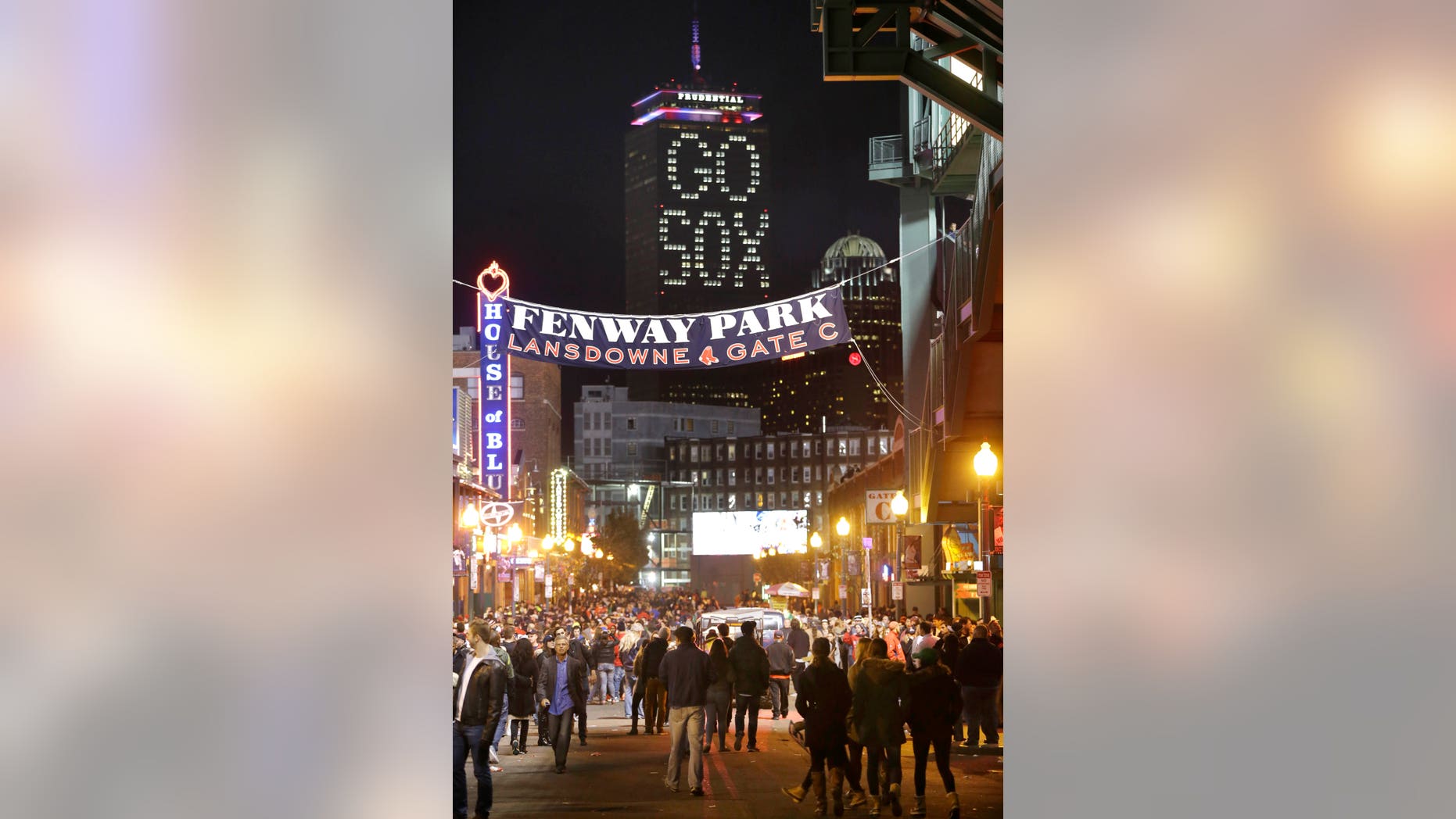 The words "Go Sox" are illuminated on a side of the Prudential Tower, top, as people walk along a street outside Fenway Park during Game 6 of baseball's World Series between the Boston Red Sox and St. Louis Cardinals, Wednesday, Oct. 30, 2013, in Boston. (AP Photo/Steven Senne)