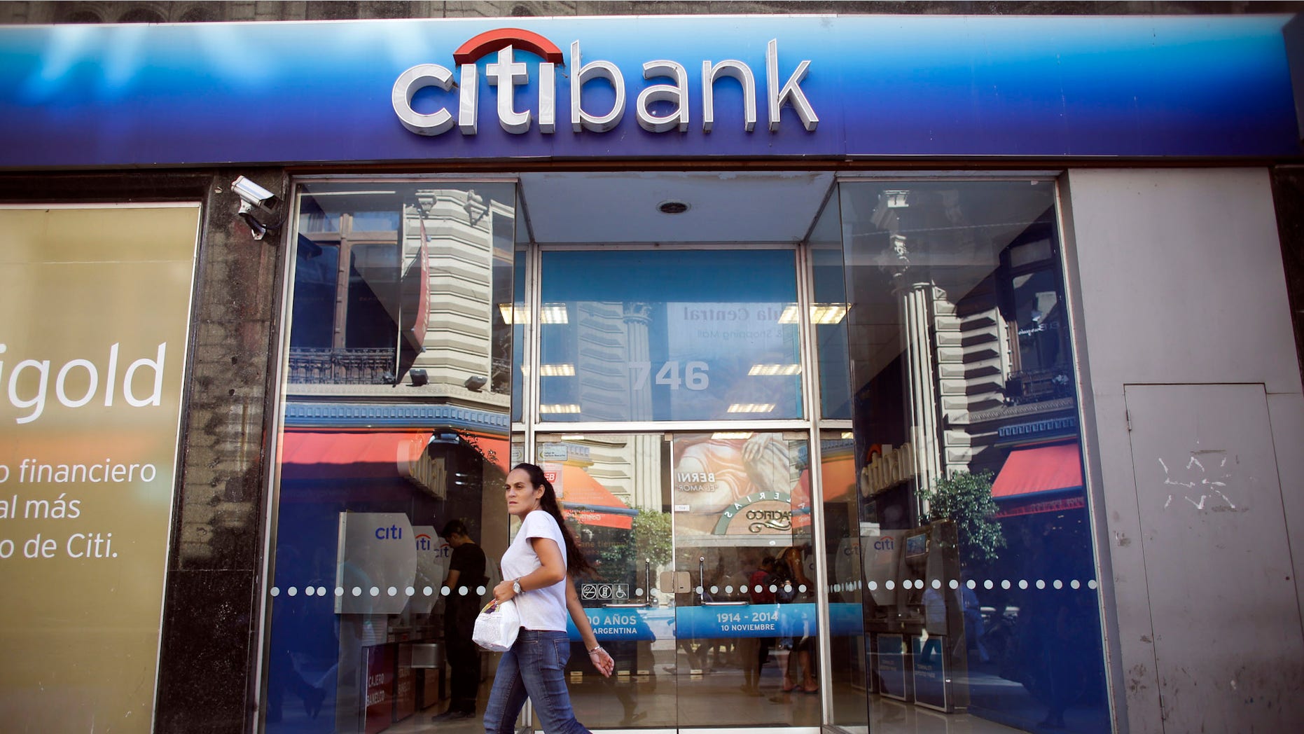 A woman walks by a Citibank branch in Buenos Aires, Argentina, Tuesday, March 17, 2015. Citibank said Tuesday it was getting out of the business of making bond payments for Argentina, the latest fallout from a bitter court fight between the South American country and a group of bondholders in the U.S. (AP Photo/Victor R. Caivano)