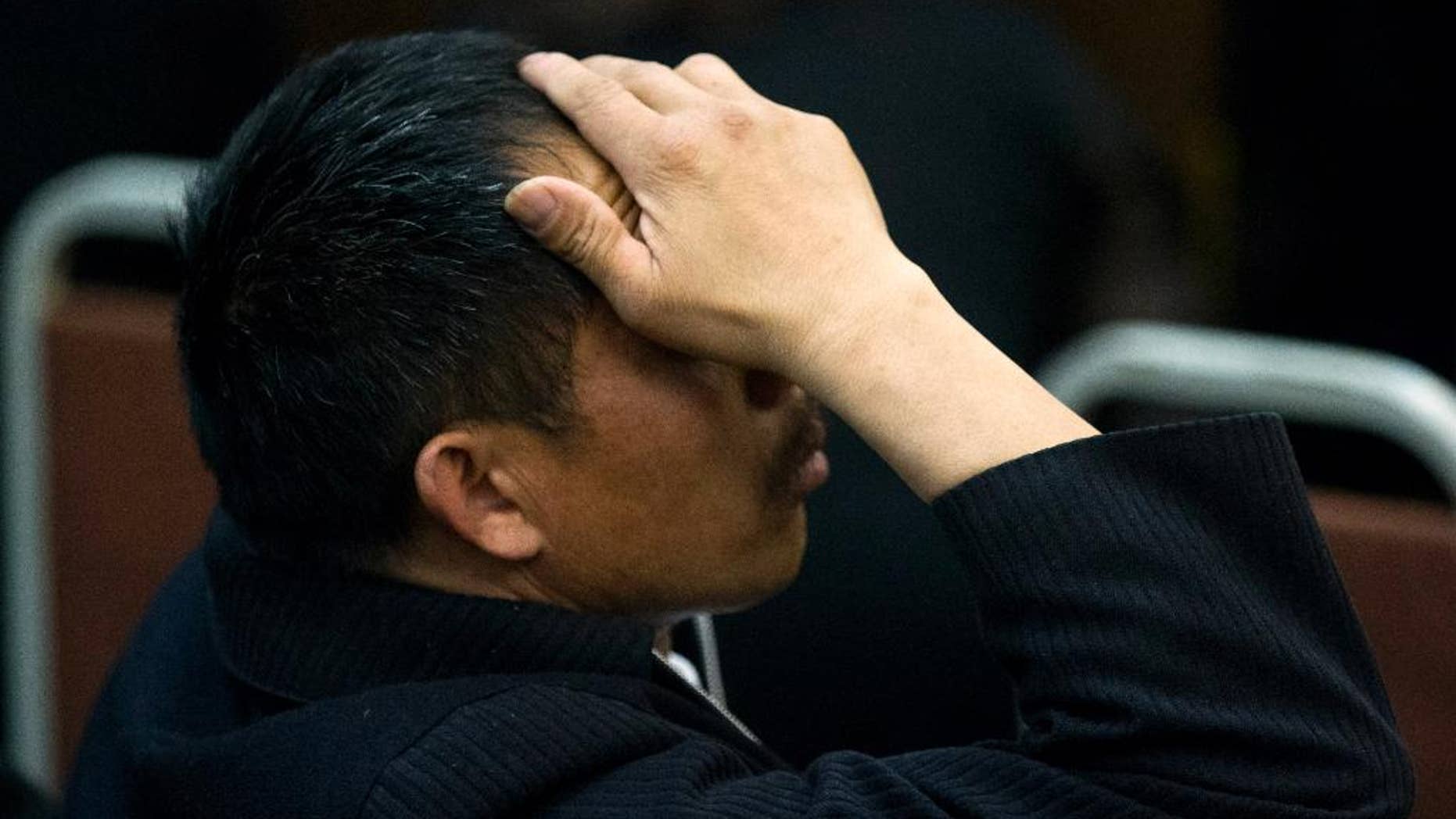 One of the relatives of Chinese passengers on board Malaysia Airlines Flight 370 rubs his head during a briefing meeting given by Malaysian official at a hotel in Beijing, China, Wednesday, March 26, 2014. The search of the missing plane resumed Wednesday after fierce winds and high waves forced crews to take a break Tuesday. A total of 12 planes and five ships from the United States, China, Japan, South Korea, Australia and New Zealand were participating in the search, hoping to find even a single piece of the jet that could offer tangible evidence of a crash and provide clues to find the rest of the wreckage. (AP Photo/Alexander F. Yuan)
