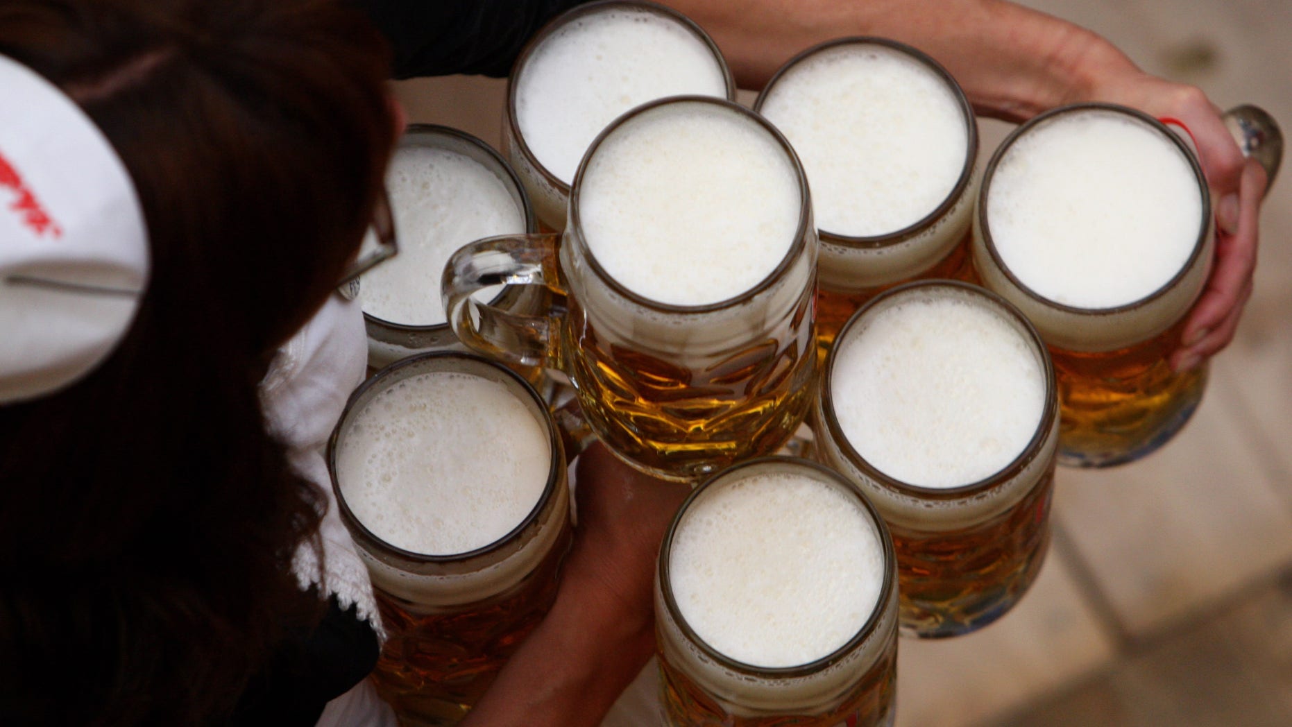 MUNICH, GERMANY - SEPTEMBER 19: A waitress carries beer mugs at the Schottenhamel beer tent on September 19, 2009 in Munich, Germany. Oktoberfest is Germany's and the world largest fair. About six million people attend the sixteen-day festival during late September and early October. (Photo by Miguel Villagran/Getty Images)