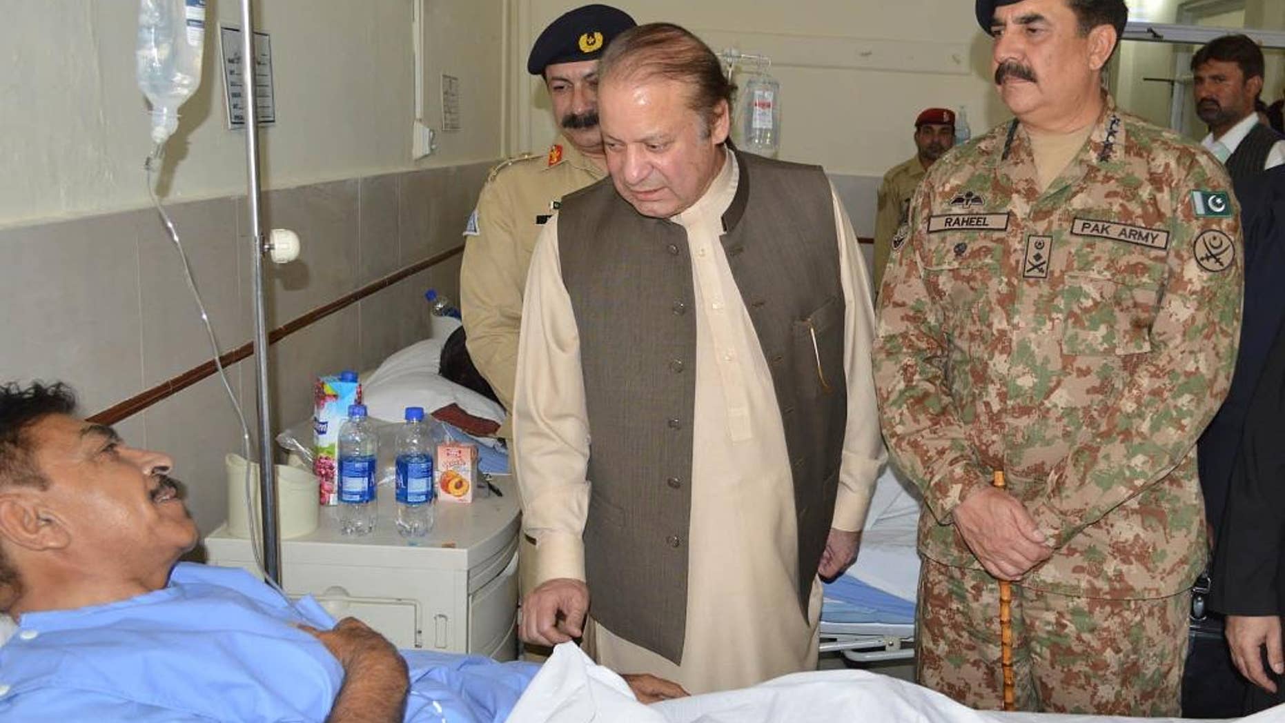 Pakistan's Prime Minister Nawaz Sharif talks to a survivor of the bombing with Pakistani army chief Gen. Raheel Sharif, right.