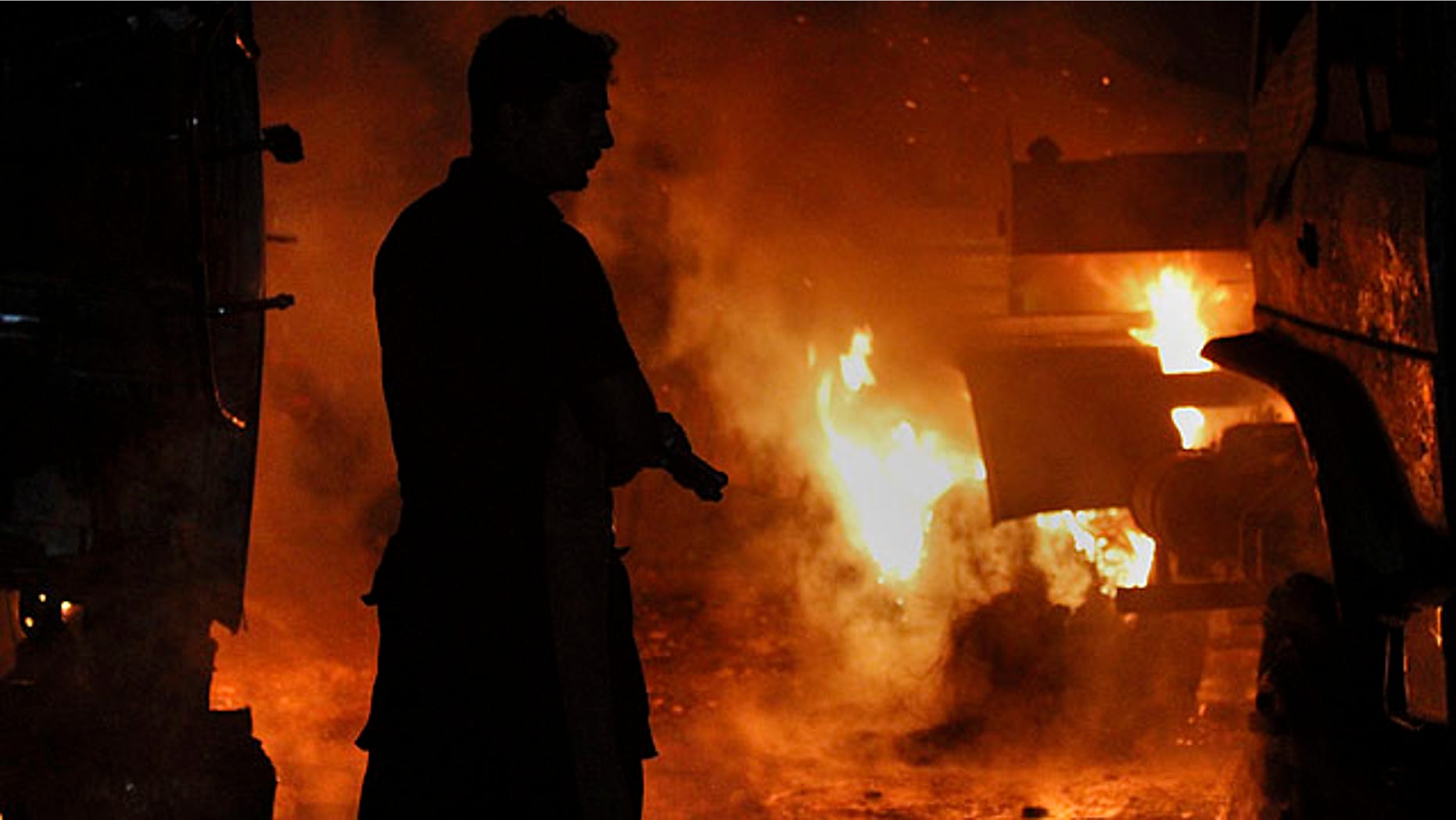 Oct. 4, 2010: A Pakistani fire fighter prepares to extinguish burning oil tankers after militants attacked a terminal in Rawalpindi, Pakistan.