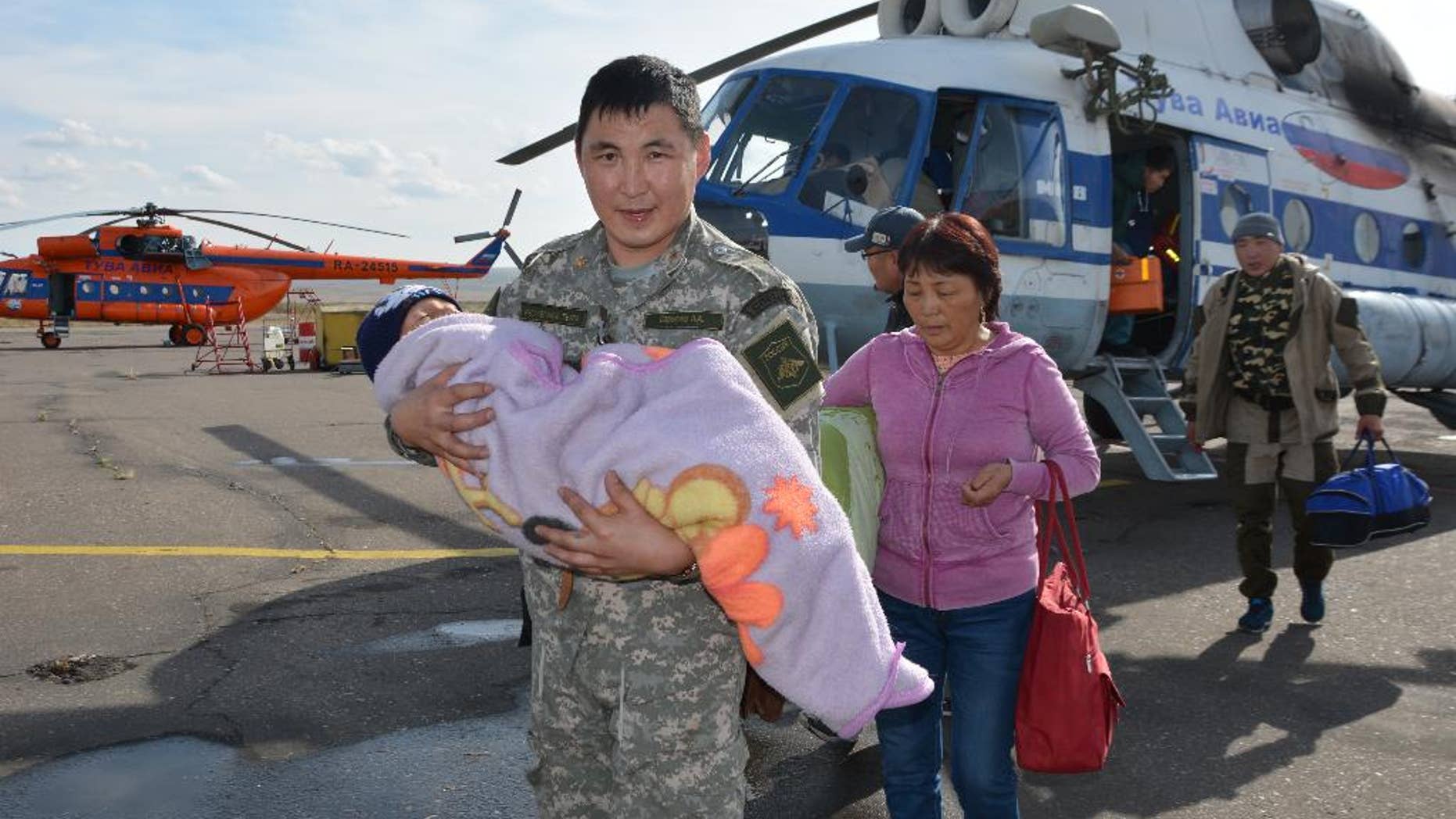 In this photo dated Wednesday, Sept. 21, 2016, provided by the Tuva Emergency Ministry Situations press service, an unidentified special force soldier carries a 3-year old boy rescued after going missing for three days in an undisclosed location in the Russian Siberian region of Tuva. The boy, who was under care of his grandmother, reportedly vanished in the woods after having followed a puppy. (Tuva Emergency Situations Ministry press service photo via AP) MANDATORY CREDIT