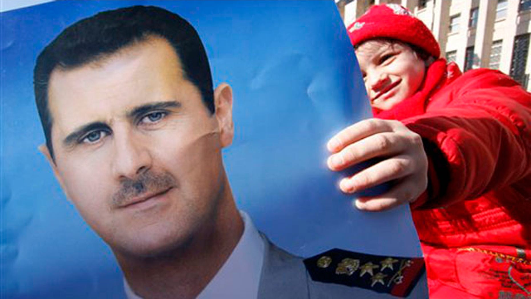 Jan. 20, 2012: A pro-Syrian regime protester holds a portrait of Syrian President Bashar Assad during a demonstration in Damascus, Syria.