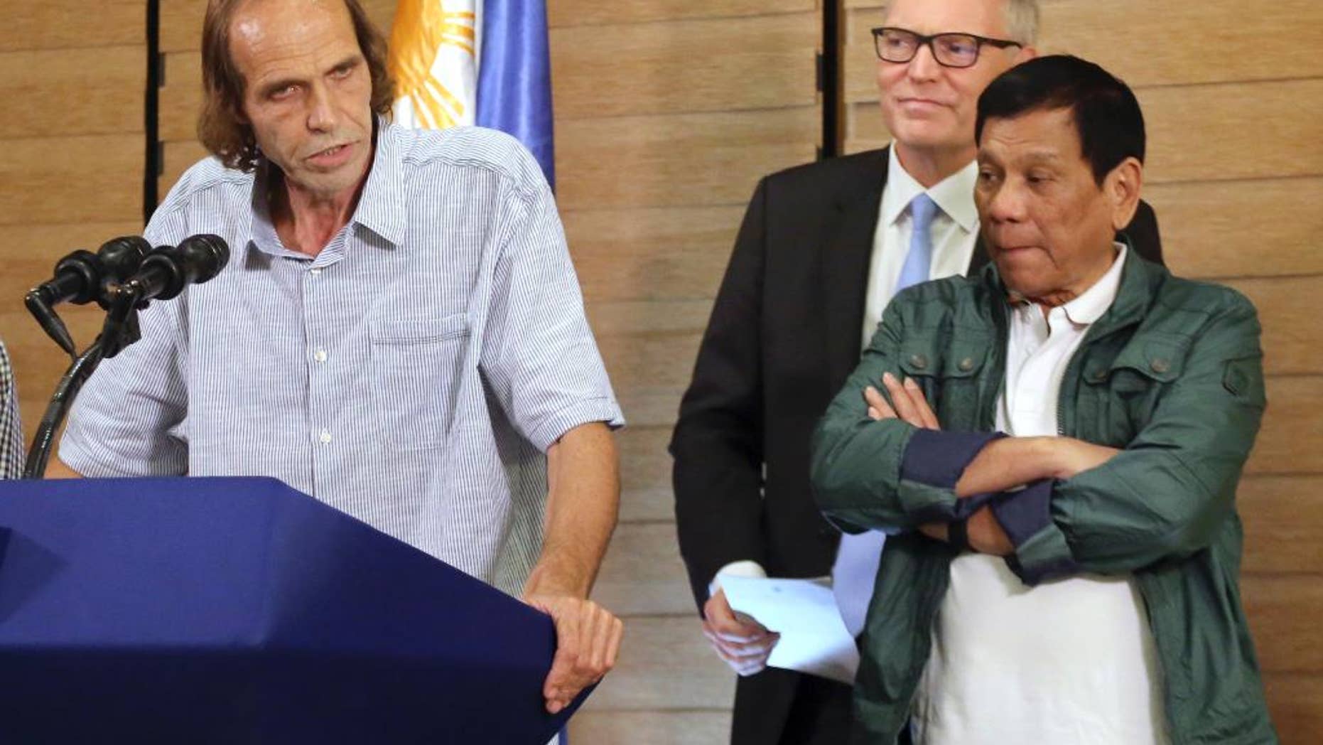 FILE - In this Sept. 18, 2016, file photo, released Norwegian hostage Kjartan Sekkingstad, left, briefly delivers his statement after meeting Philippine President Rodrigo Duterte, right, in Davao city in southern Philippines. Sekkingstad was freed after a year of horrific jungle captivity when he was constantly threatened with beheading. Abu Sayyaf militants pocketed at least 353 million pesos ($7.3 million) from ransom kidnappings in the first six months of the year and have turned to abductions of foreign tugboat crewmen as military offensives restricted the gunmen's mobility, a confidential Philippine government report said Thursday, Oct. 27, 2016. (AP Photo/Manman Dejeto, File)