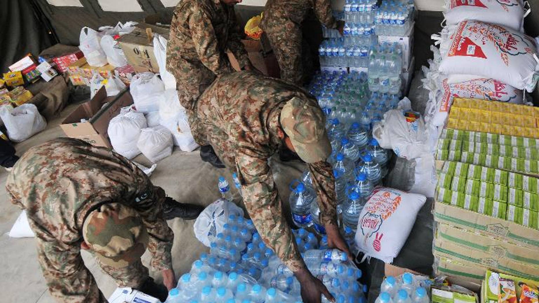 Pakistani army soldiers arrange relief supplies for earthquake survivors in Lahore on September 29, 2013.