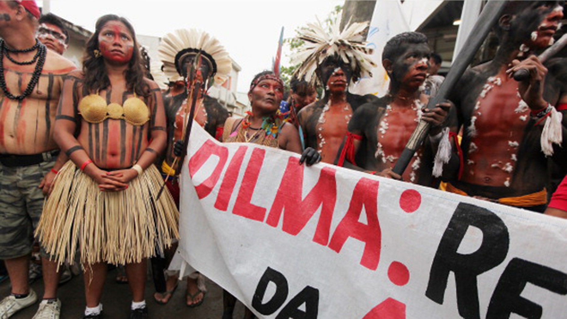 Indigenous and protesters look on during a march through the decades-old Vila Autodromo squatter settlement before demonstrating outside an entrance to the Rio + 20 conference on June 20, 2012 in Rio de Janeiro, (Photo by Mario Tama/Getty Images)