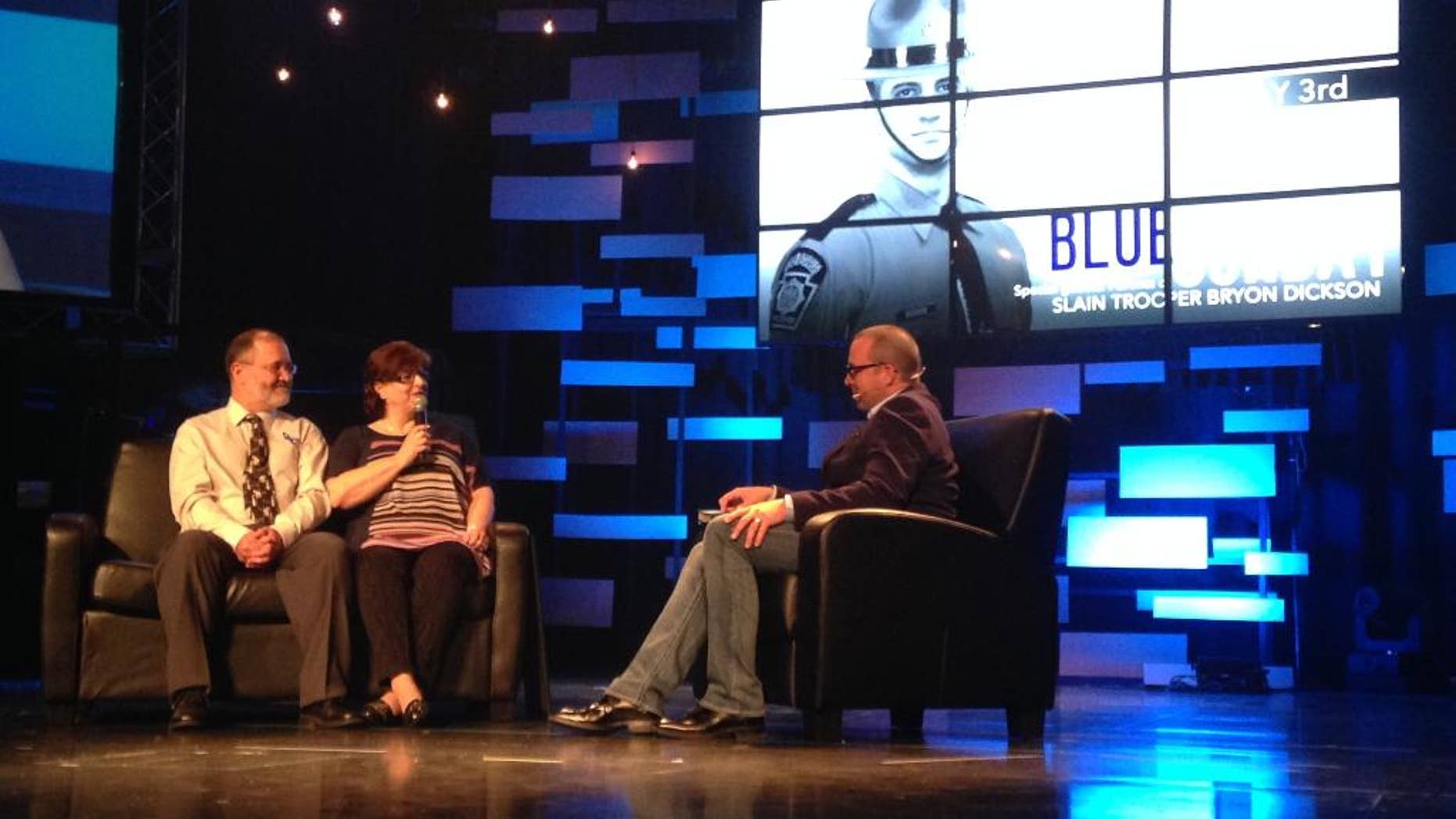 FILE - In this May 3, 2015 file photo, parents Bryon Dickson, left, and his wife Darla Dickson, center, speak about their son, Cpl. Bryon Dickson II, with David Crosby Jr., pastor of Community Church during a service in Tobyhanna, Pa. Eric Frein, the would-be revolutionary who shot two Pennsylvania troopers, one fatally, in a late-night attack at their barracks, was sentenced to death late Wednesday, April 26, 2017. Cpl. Dickson II, a Marine veteran and married father of two, was killed, and Trooper Alex Douglass was critically wounded. (AP Photo/Michael Rubinkam, File)