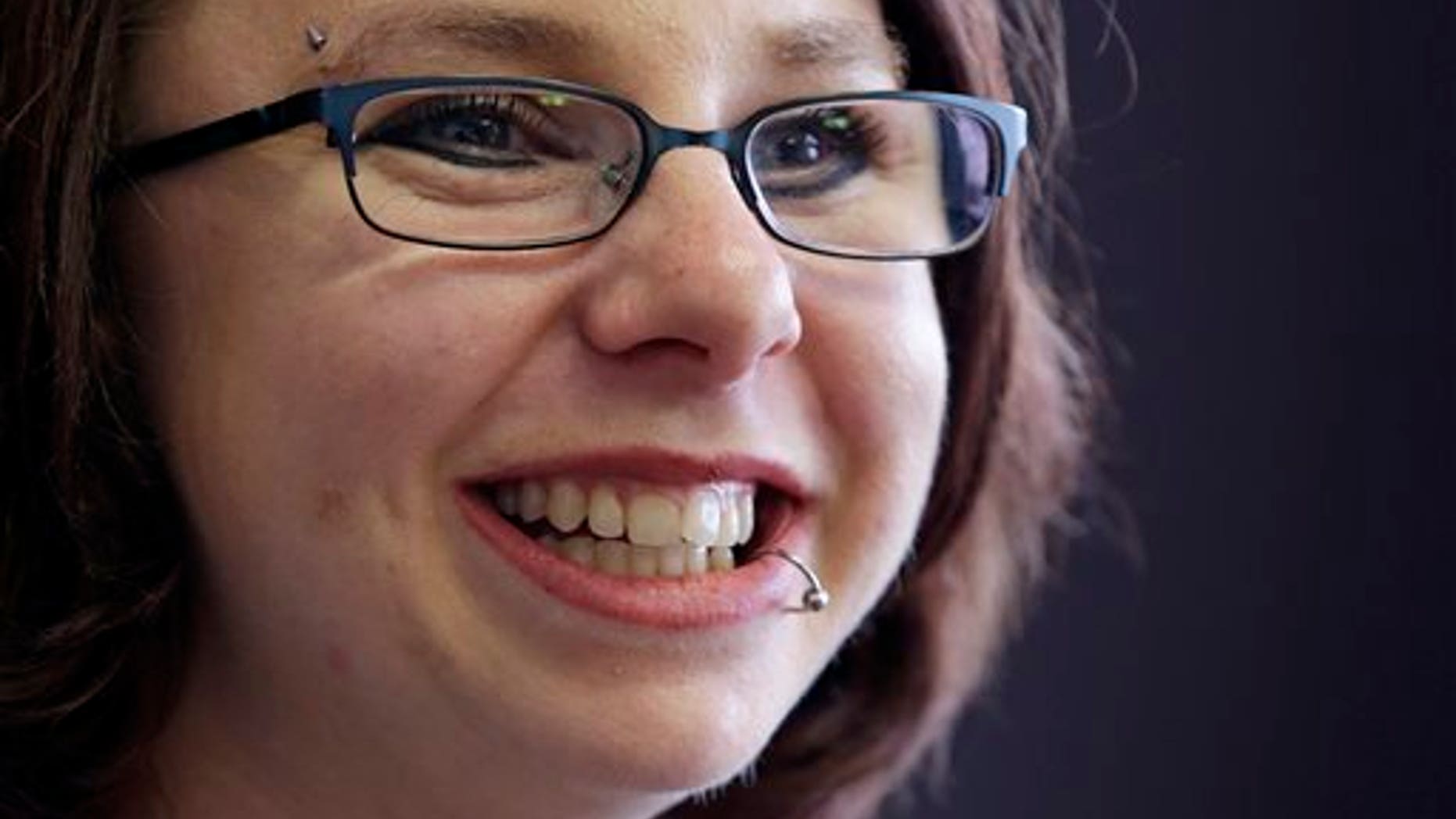 FILE - In this Thursday, June 26, 2014, file photo, Michelle Knight smiles during an interview in Cleveland. During an interview on Sunday, Oct. 19, 2014, Knight, one of the three women held captive in a Cleveland home for about a decade, said she has been able to forgive her kidnapper, Ariel Castro, and find peace in her life. (AP Photo/Tony Dejak, File)