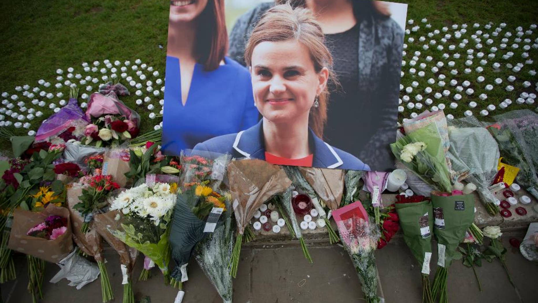 FILE - This is a Friday, June 17, 2016, file photo of an image and floral tributes for Jo Cox, in Parliament Square, outside the House of Parliament in London, after the 41-year-old British Member of Parliament was fatally injured in northern England. A jury Wednesday Nov. 23, 2016 found Thomas Mair with white supremacist views guilty of murdering Labour lawmaker Jo Cox a week before Britain's EU membership referendum. (AP Photo/Matt Dunham, File)
