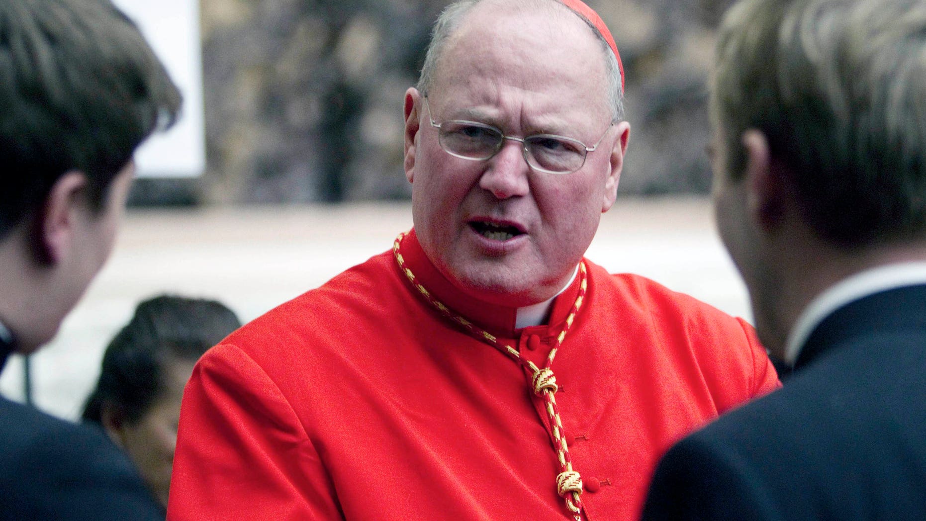 In this Saturday, Feb. 18, 2012 file photo, Cardinal Timothy Dolan, archbishop of New York, is congratulated by two unidentified prelates after being elevated in St. Peter's Basilica at the Vatican. According to a spokesman from the Archdiocese of New York City, Dolan has been deposed in New York on Wednesday, Feb. 20, 1023 in connection to accusations of sexual abuse in the Archdiocese of Milwaukee. (AP Photo/Andrew Medichini, File)