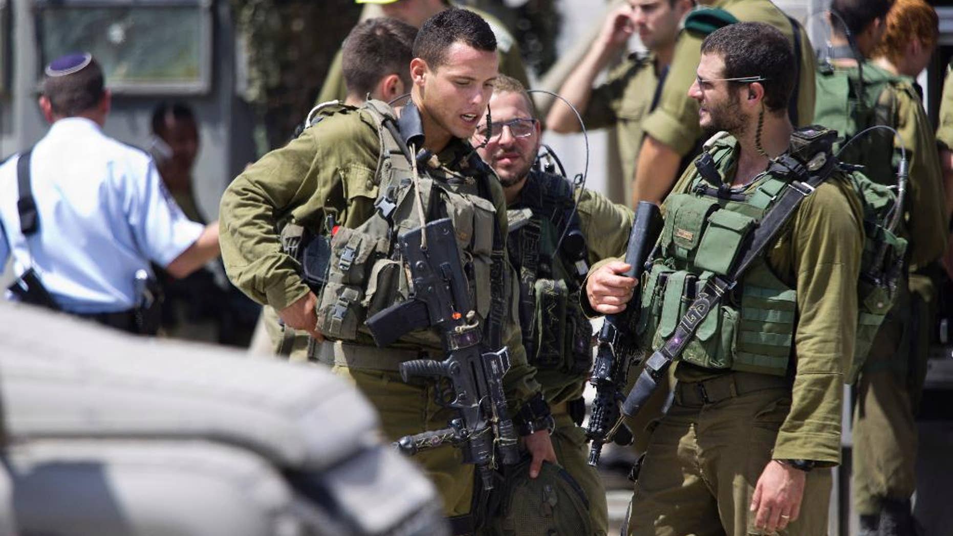Aug. 17, 2015: Israeli soldiers stand guard at a checkpoint near the West Bank of Nablus. Israel authorities say troops have shot and killed a Palestinian after he stabbed a guard at a West Bank checkpoint. Police spokeswoman Luba Samri says the man approached border police officers manning a checkpoint on Monday and told them he felt unwell.