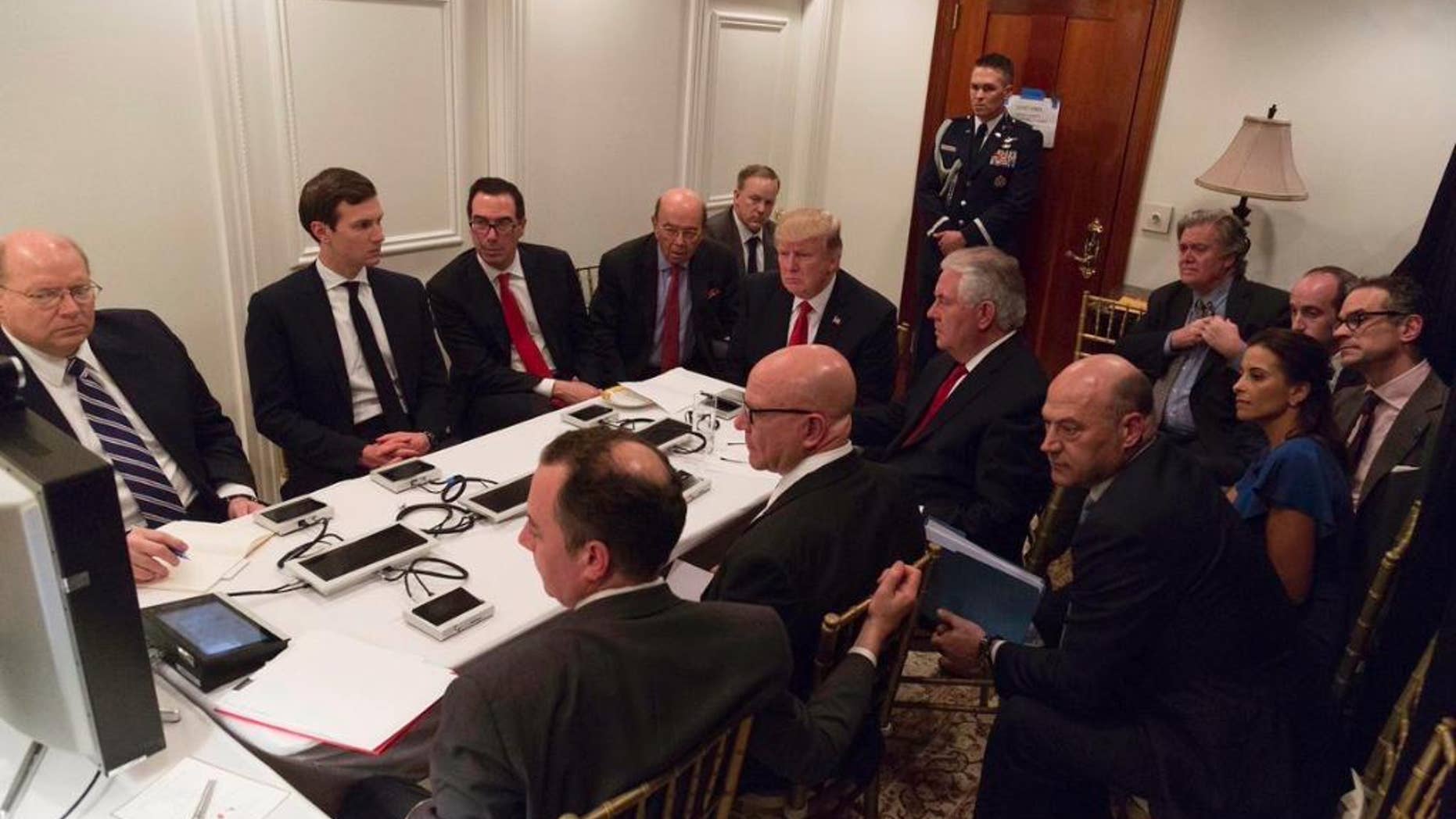 In this image provided by the White House, President Donald Trump receives a briefing on the Syria military strike from his National Security team after the strike at Mar-a-Lago in Palm Beach, Fla., Thursday night, April 6, 2017. (White House via AP)