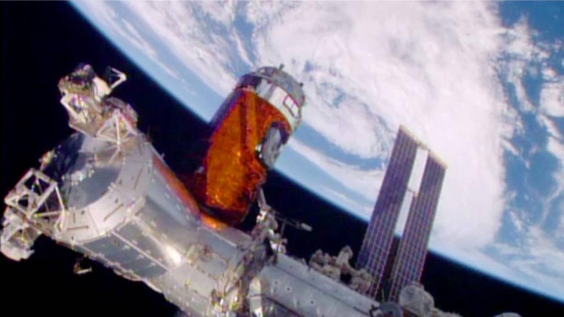 In a photo provided by NASA, a cargo ship from a Japanese company is bolted into place on the International Space Station Monday, Aug. 24, 2015. A Japanese company known for its whiskey and other alcoholic beverages included five types of distilled spirits in the cargo ship that arrived at the space station Monday. The samples will spend at least a year in orbit to see if alcoholic beverages mellow the same in space as they do on Earth. The station’s big robotic arm, operated by Japanese astronaut Kimiya Yui, grabbed onto the supply craft launched Wednesday by his homeland. Flight controllers helped anchor it down. NASA also has considerable equipment aboard the supply capsule. (NASA via AP)