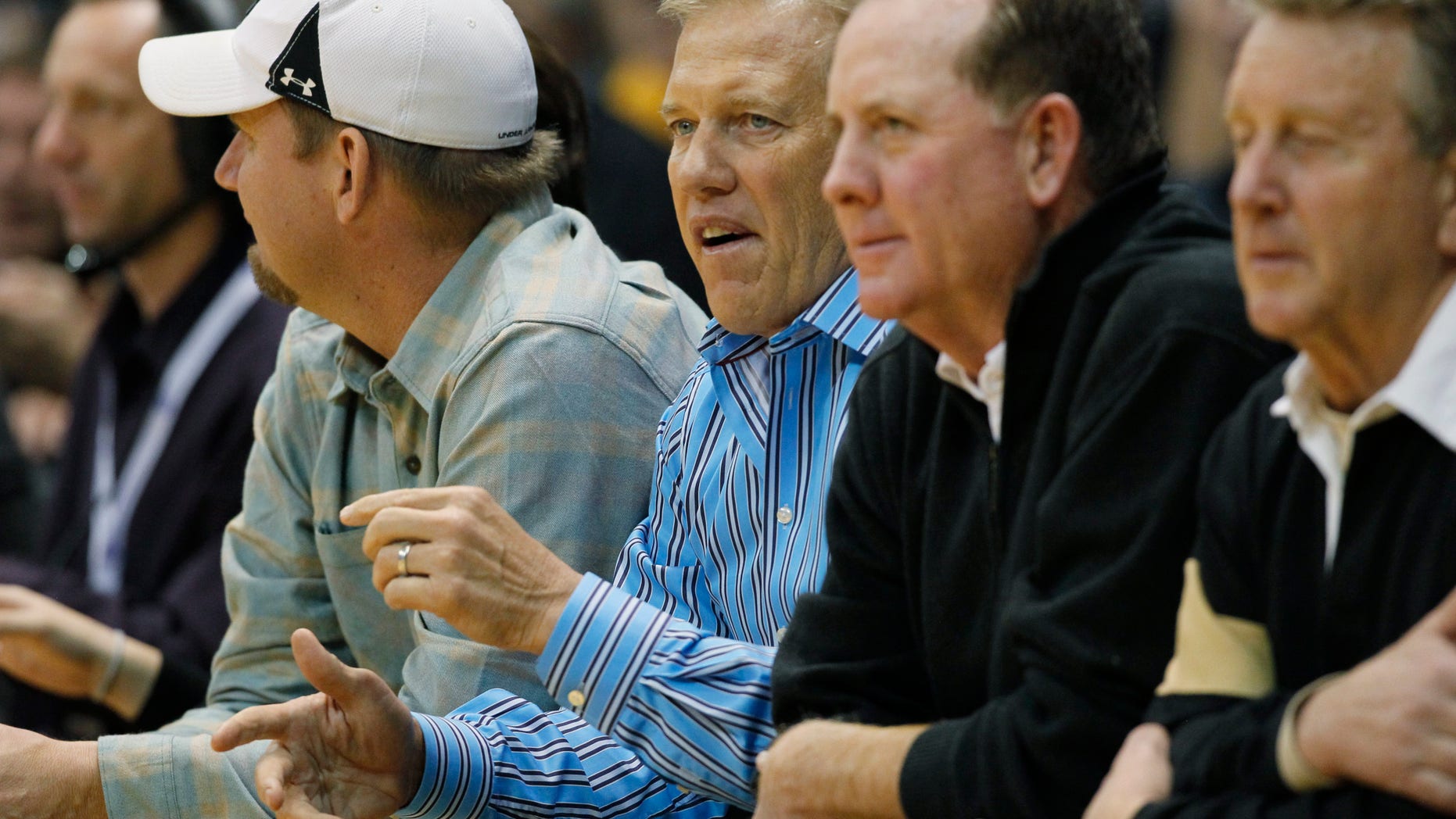 John Elway, center, executive vice president of football operations for the Denver Broncos, takes a courtside seat to watch Colorado host Arizona in the first half of an NCAA college basketball game in Boulder, Colo., on Thursday, Feb. 14, 2013. (AP Photo/David Zalubowski)