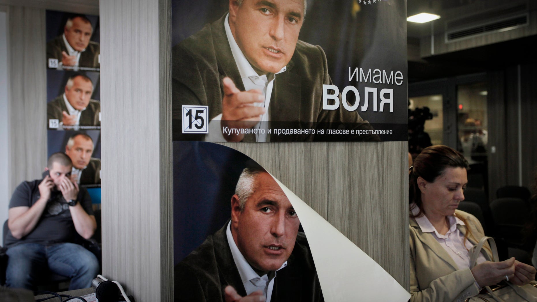 Journalists wait in a press-room covered with posters of Boyko Borisov, former Prime Minister and leader of center-right GERB party, in Sofia, Tuesday, May 14, 2013. The center-right party of former Prime Minister Boiko Borisov has fallen far short of winning a majority needed to form a government, according to nearly final election results released on Monday, and appears to have no willing partners to join a coalition. (AP Photo/Valentina Petrova)