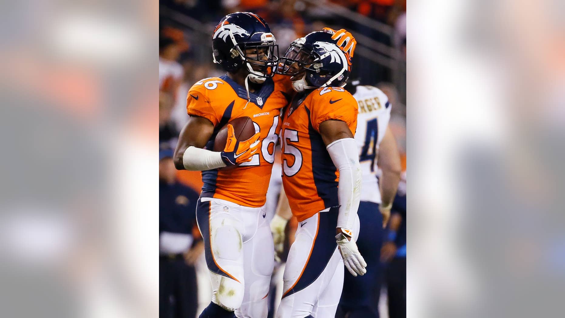 San Diego Chargers cornerback Brandon Flowers (26) celebrates his interception with teammate Chris Harris (25) during the second half of an NFL football game against the San Diego Chargers, Thursday, Oct. 23, 2014, in Denver. (AP Photo/Jack Dempsey)