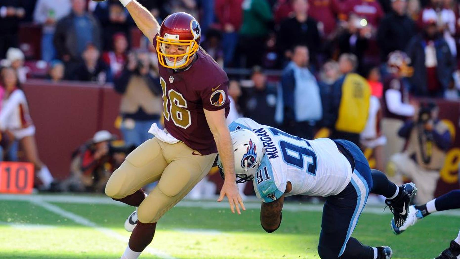 Washington Redskins quarterback Colt McCoy (16) avoids Tennessee Titans outside linebacker Derrick Morgan (91) during the second half of an NFL football game, Sunday, Oct. 19, 2014, in Landover, Md. The Redskins won 19-17. (AP Photo/Richard Lipski)