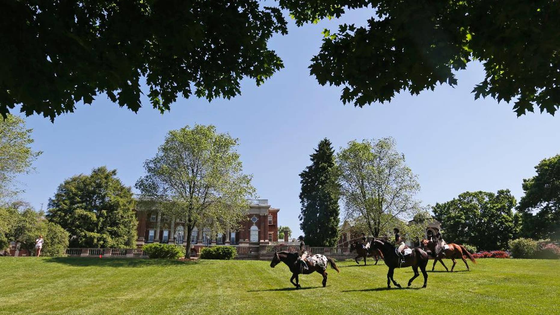 FILE This Wednesday May 13, 2015 file photo show graduating seniors at Sweet Briar college participate on the tradition Senior ride on the quad at the school in Sweet Briar, Va. The senior ride is a tradition where seniors are allowed to ride horses on school grounds. The Supreme Court of Virginia justices are scheduled to hear an appeal Thursday, June 4, 2015, of a failed bid to block the small college from shuttering its picturesque Blue Ridge Mountains campus in August. (AP Photo/Steve Helber)