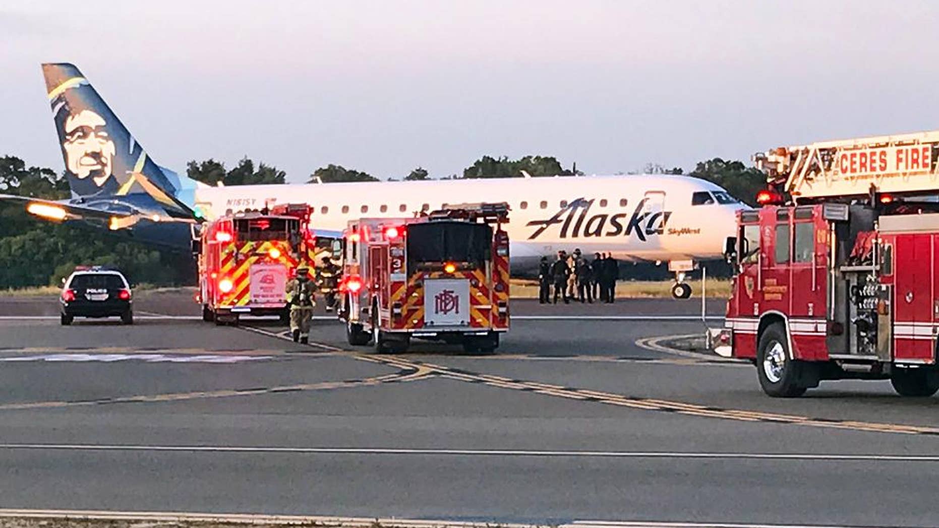This photo provided by the Modesto, Calif., Fire Department shows an Alaska Airlines Embraer 175 twin jet after it made an unscheduled landing at the Modesto airport Sunday, April 9, 2017. Authorities said the flight headed from Sacramento to San Diego was forced to make the unexpected landing after a warning light indicated a possible fire in the plane's cargo area. It landed without incident in Modesto on Sunday. (Modesto Fire Department via AP)