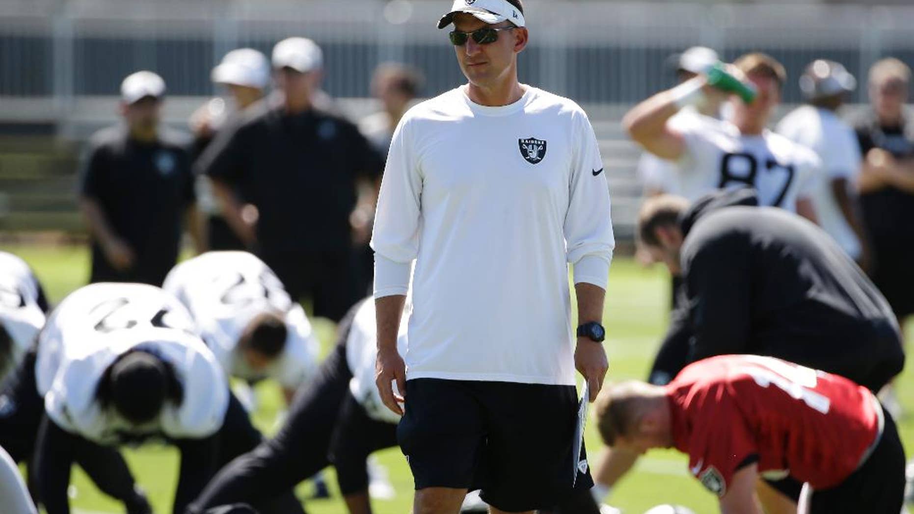 Oakland Raiders coach Dennis Allen watches players stretch during NFL football training camp Friday, July 25, 2014, in Napa, Calif. (AP Photo)