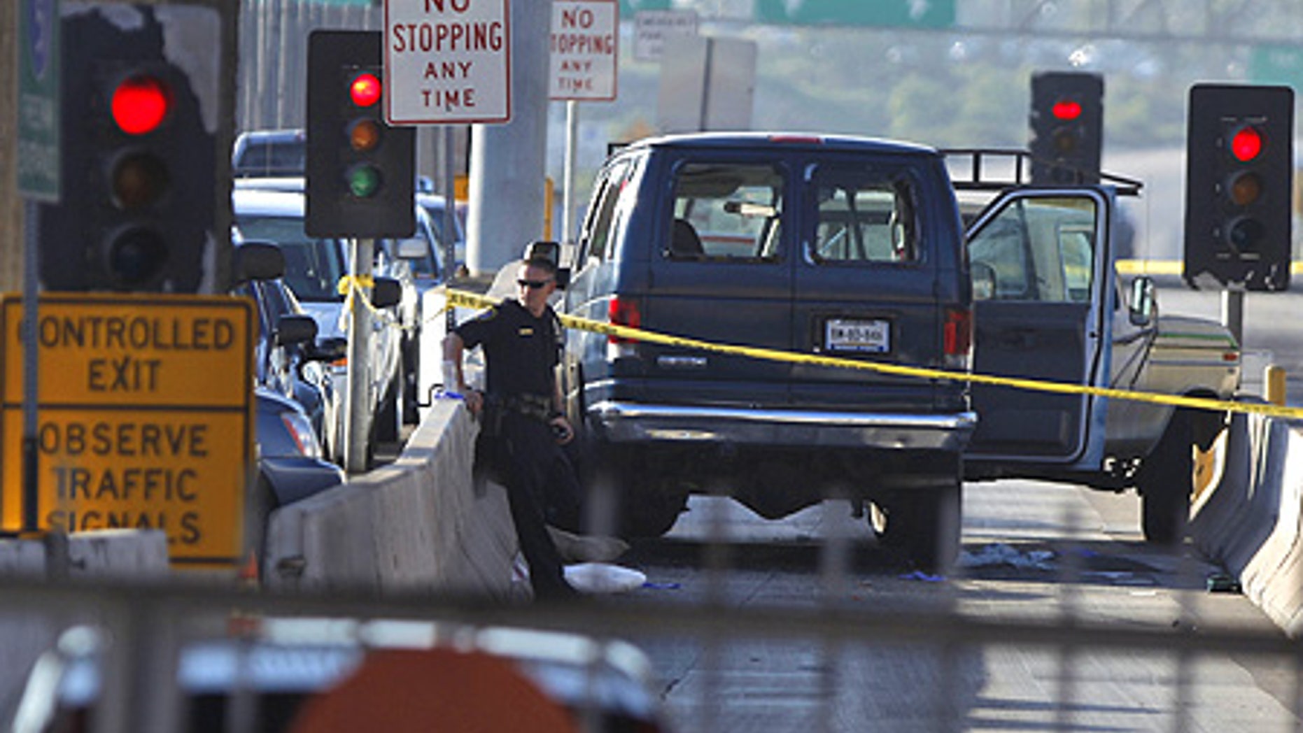 Sept. 22: A U.S. border officer is seen from Mexico's side of the San Ysidro port of entry guarding vehicles involved in a shooting.