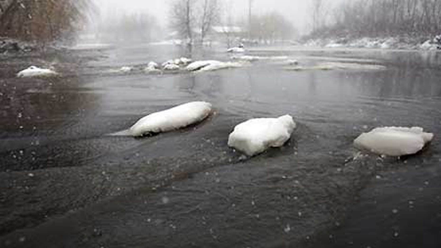 March 31, 2009: Icy floodwaters flow over a road in Fargo, N.D., in blizzard conditions as Red River floodwaters continue to drop.