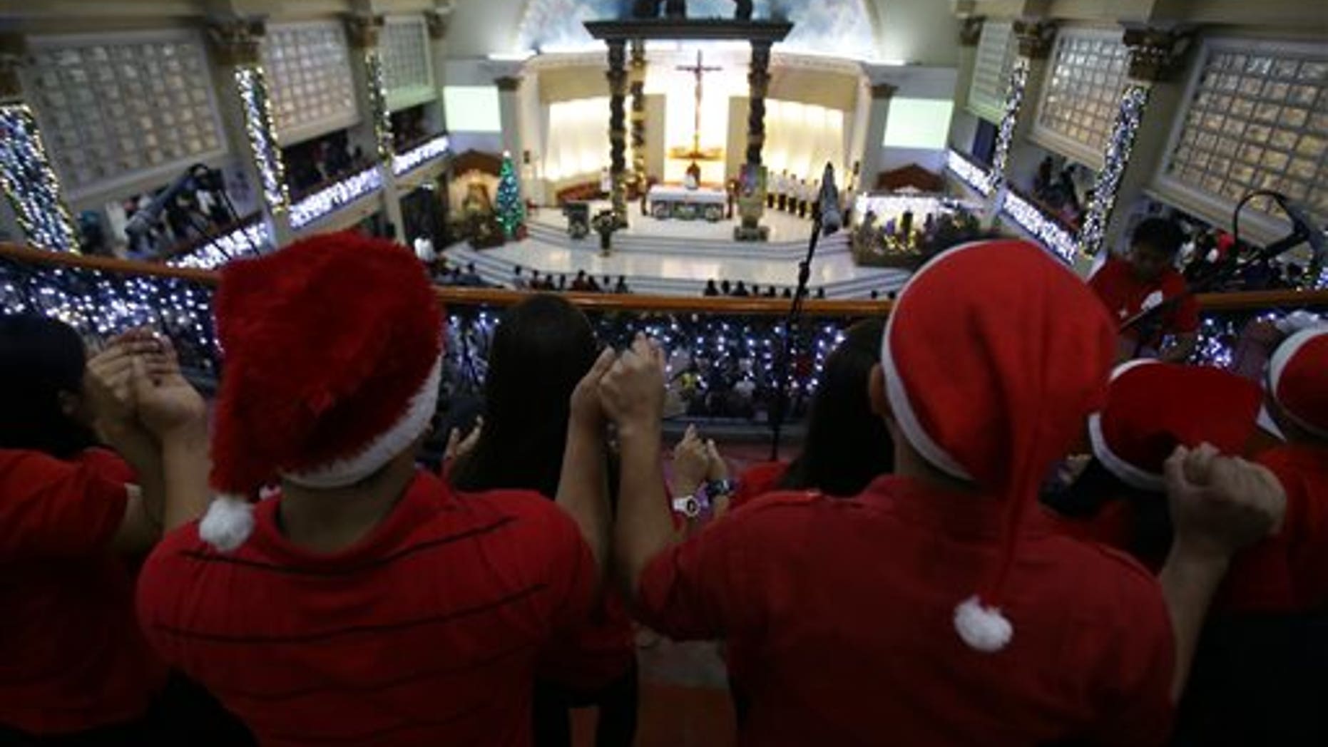 A Filipino Catholics choir hold hands as they sing during the first of nine daily dawn Masses before Christmas day at the St. Peter Parish in suburban Quezon city, north of Manila, Philippines on Wednesday, Dec. 16, 2015. This centuries-old tradition was said to have been started by farmers who wanted to fulfill their religious obligation before the day's work in the field. Christmas is the longest holiday celebration in this predominantly Roman Catholic nation.(AP Photo/Aaron Favila)