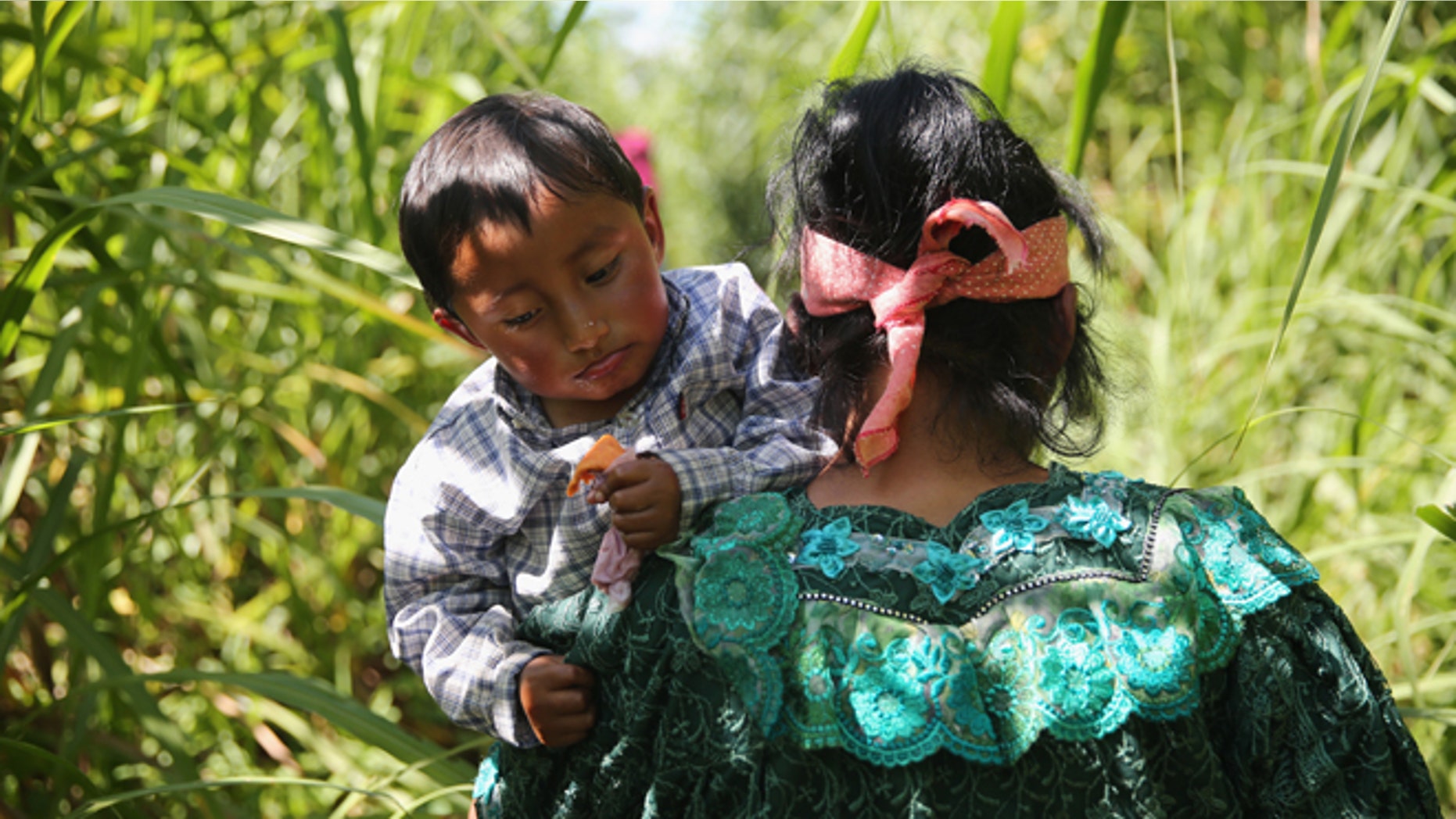 TALISMAN, MEXICO - AUGUST 01: An Indigenous family walks from Guatemala into Mexico after illegally crossing the border at the Suchiate River on August 1, 2013 in Talisman, Mexico. They passed directly under a bridge with a Mexican immigration checkpoint. Thousands of Central Americans pass illegally into Mexico daily, many on the first leg of their long and perilous journey north towards the United States. (Photo by John Moore/Getty Images)