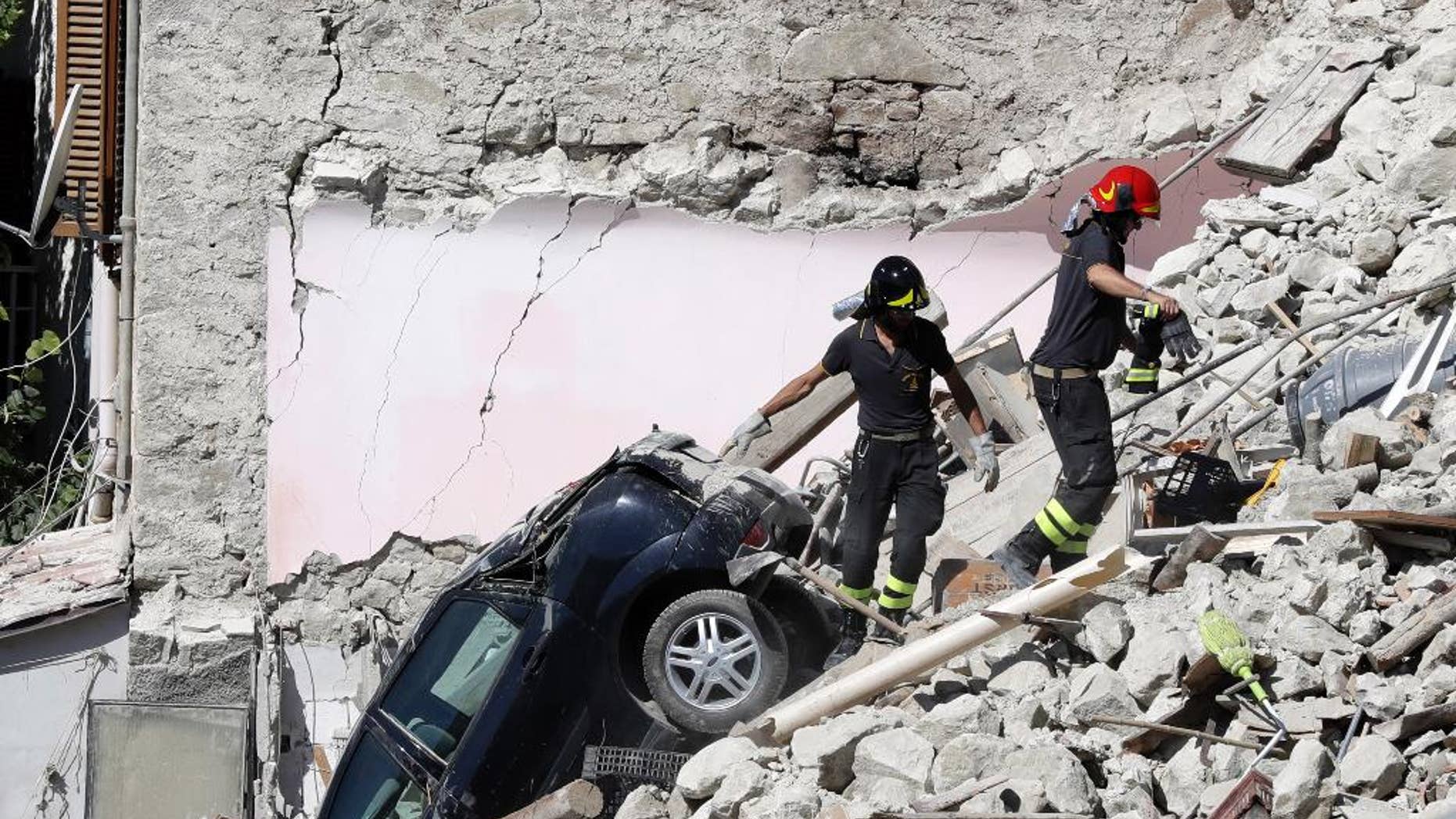 Rescuers make their way through destroyed houses following Wednesday's earthquake in Pescara Del Tronto, Italy, Thursday, Aug. 25, 2016. Rescue crews raced against time Thursday looking for survivors from the earthquake that leveled three towns in central Italy, but the death toll rose to 247 and Italy once again anguished over trying to secure its medieval communities built on seismic lands. (AP Photo/Gregorio Borgia)