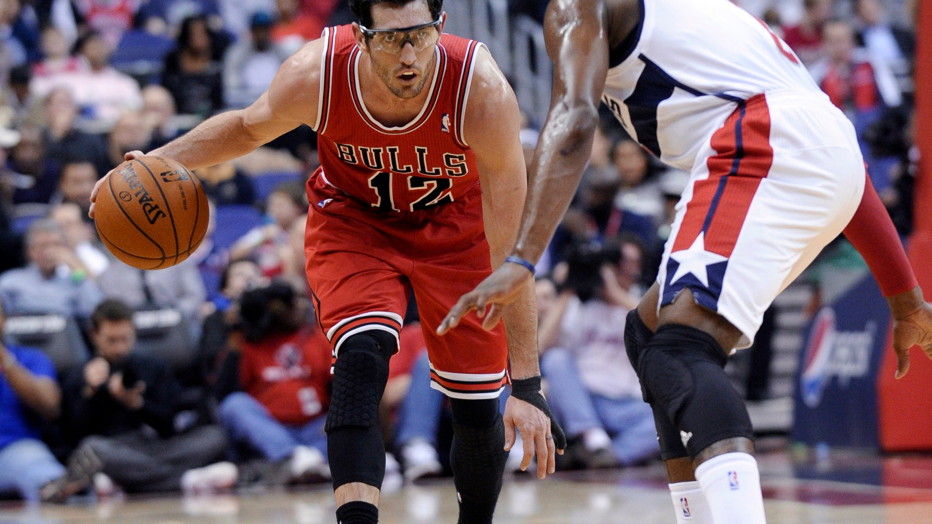 Chicago Bulls guard Kirk Hinrich (12) eyes Washington Wizards point guard John Wall during the first quarter of an NBA basketball game in Washington, Friday, Jan. 17, 2014. The Wizards won 96-93. (AP Photo/Susan Walsh)