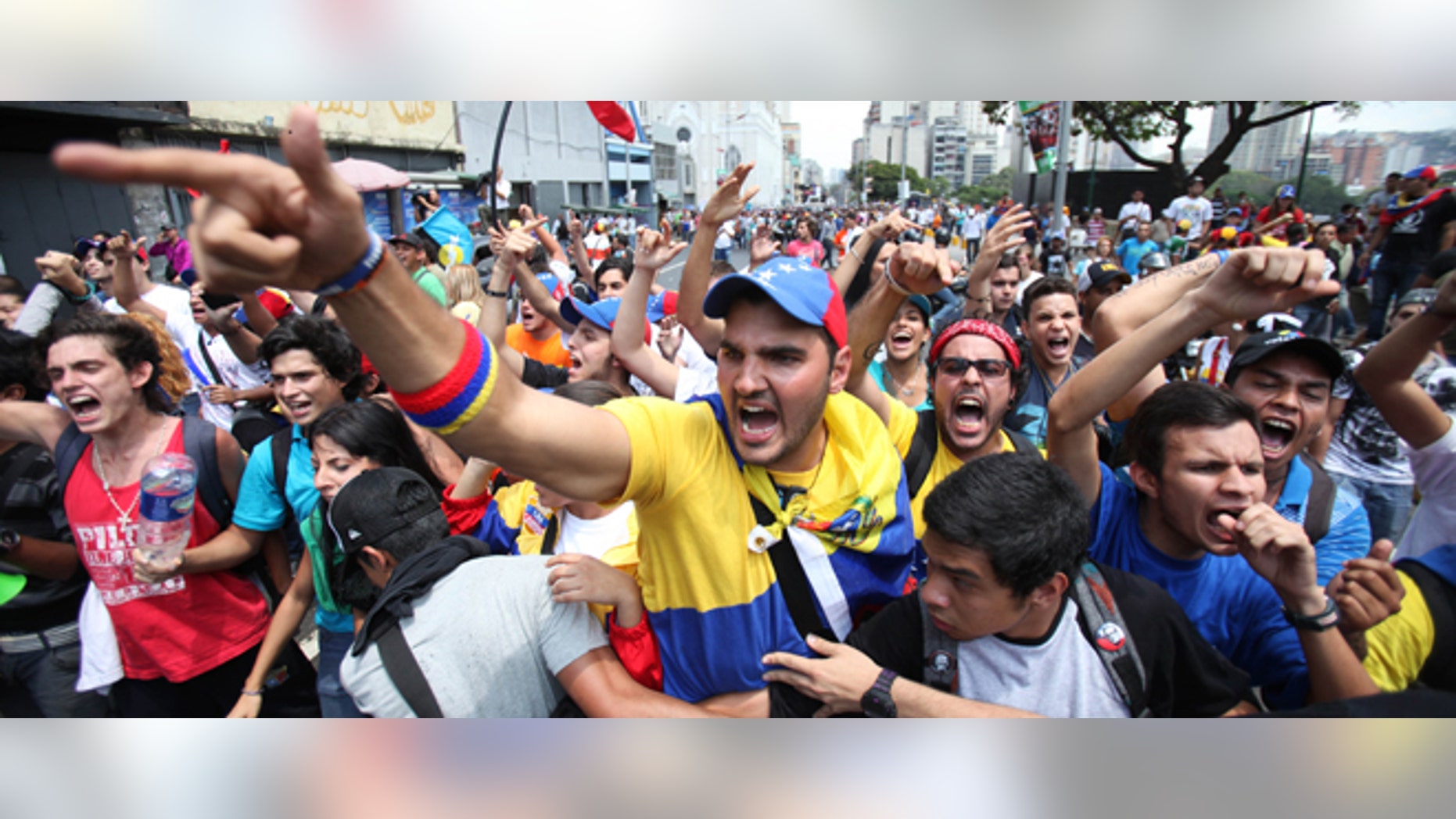 Opposition students shouts slogans against supporters of Venezuela's late President Hugo Chavez during a protest a few blocks from the electoral commission in Caracas, Venezuela, Thursday, March 21, 2013. The students were asking that the commission eliminate requirements that voters have their fingerprints recorded before voting. They were also demanding the government not interfere in politics ahead of an April 14 vote to replace Chavez. (AP Photo/Fernando Llano)