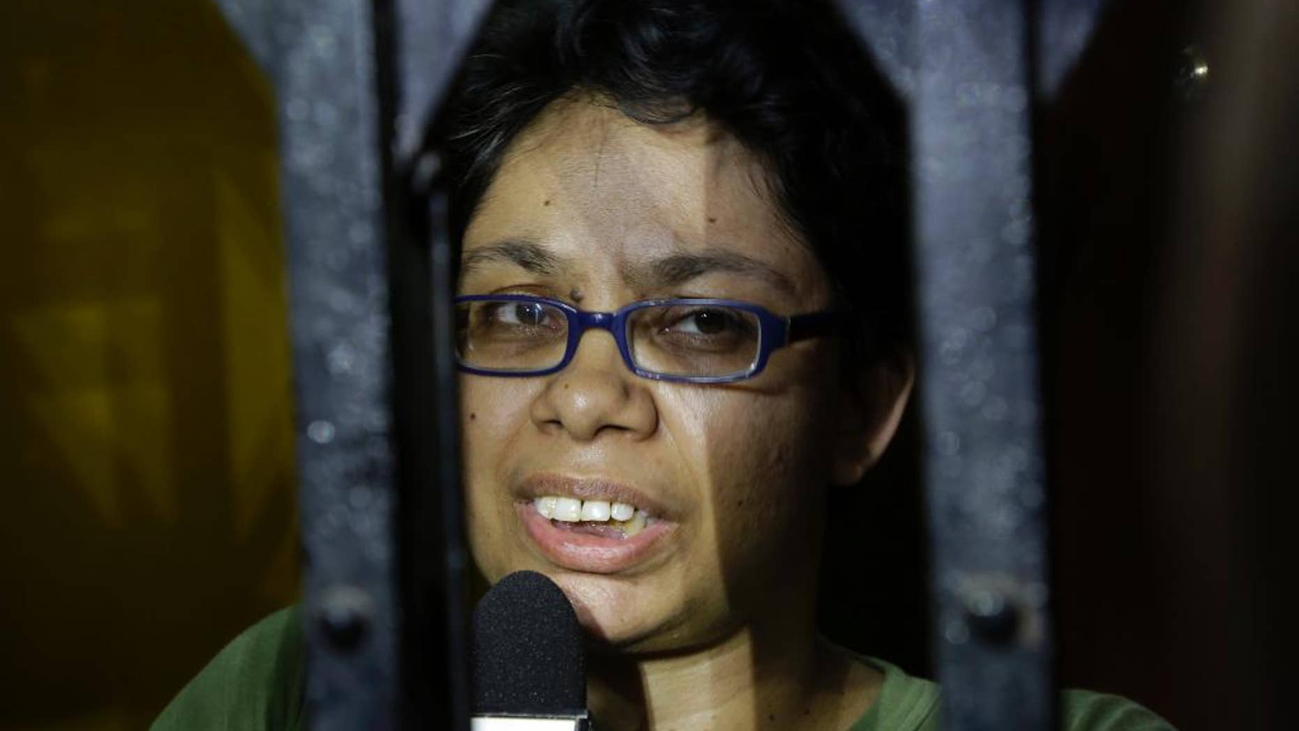 Agnes D'Souza, sister of Judith D'Souza who has allegedly been kidnapped in Afghanistan, talks to journalists from behind the front gate of their apartment in Kolkata, India, Friday, June 10, 2016. The 40-year-old worker was hired by the Aga Khan Foundation, which provides education and health assistance in about 30 countries. (AP Photo/ Bikas Das)