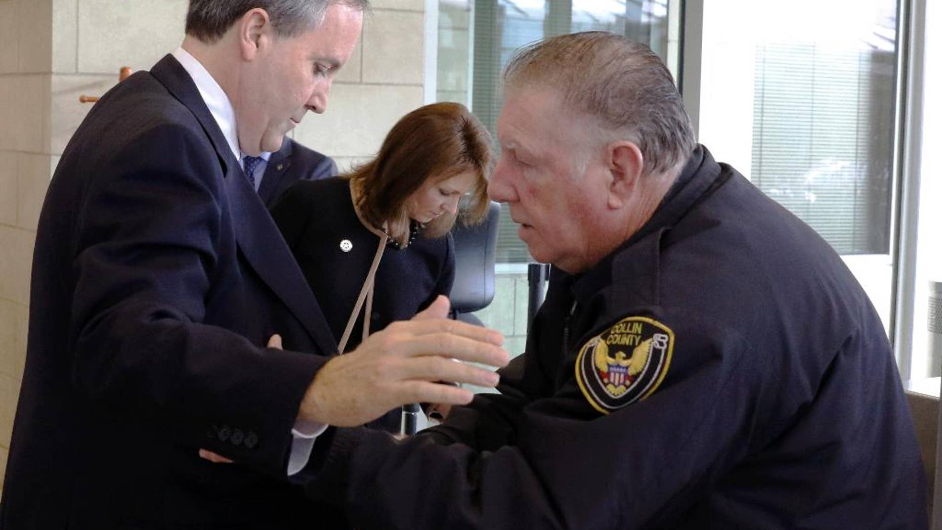 Texas Attorney General Ken Paxton and his wife Angela go through security before entering the Collin County Courthouse for a hearing on Tuesday, Dec.1, 2015 in McKinney, Texas. Paxton is accused of encouraging wealthy investors to pump more than $100,000 into a tech startup called Servergy without revealing he was being paid by the company. (David Woo/The Dallas Morning News via AP, Pool)