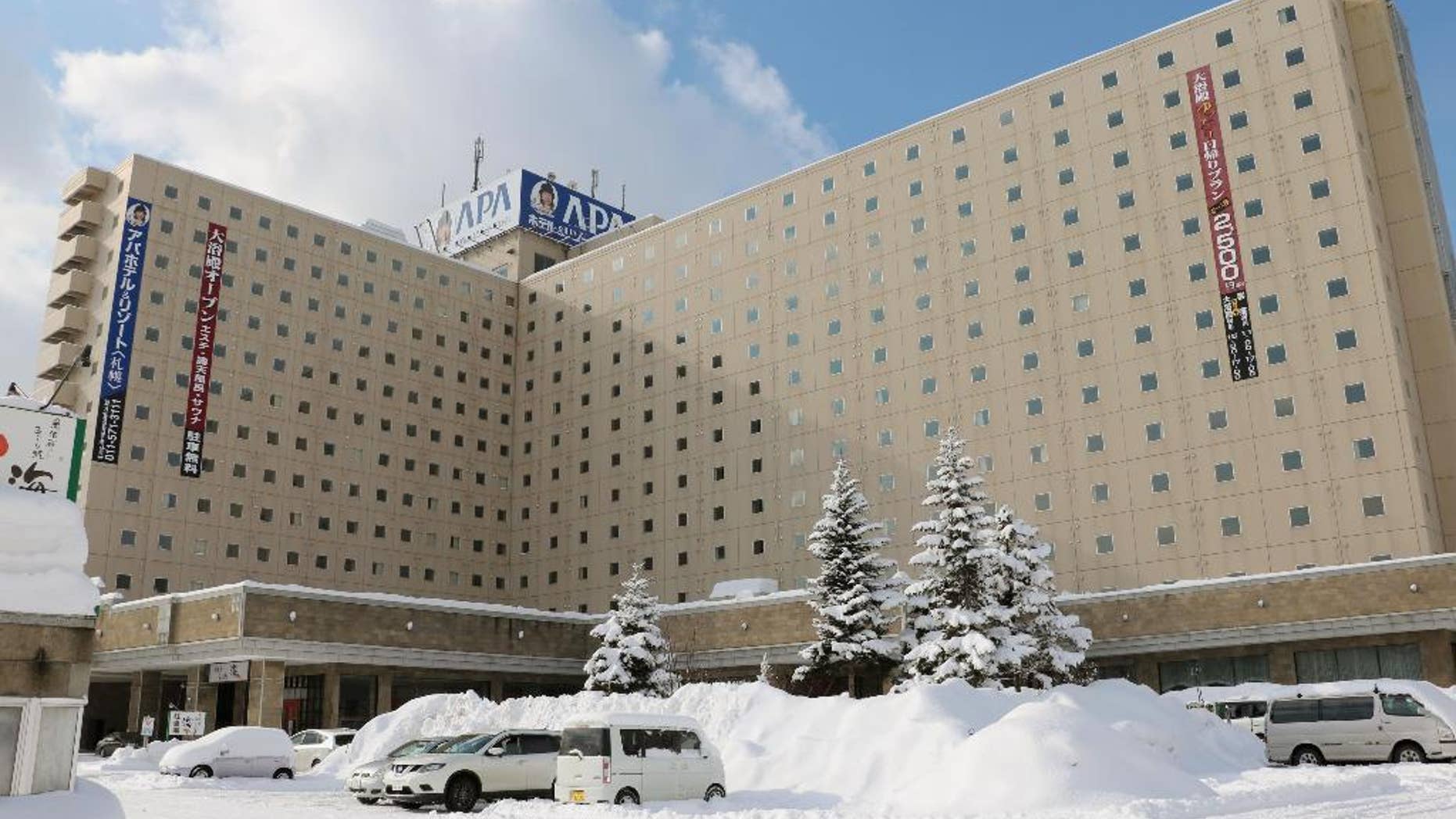 Snow-covered vehicles are parked in front of APA Hotel in Sapporo, northern Japan, Tuesday, Jan. 31, 2017. Japanese organizers for next month’s Asian Winter Games say nationalistic history books will be removed from guestrooms at the hotel that will be used to house athletes. The organizers also say Chinese athletes will stay at another hotel in accordance with a request from Beijing. (Kentaro Watanabe/Kyodo News via AP)