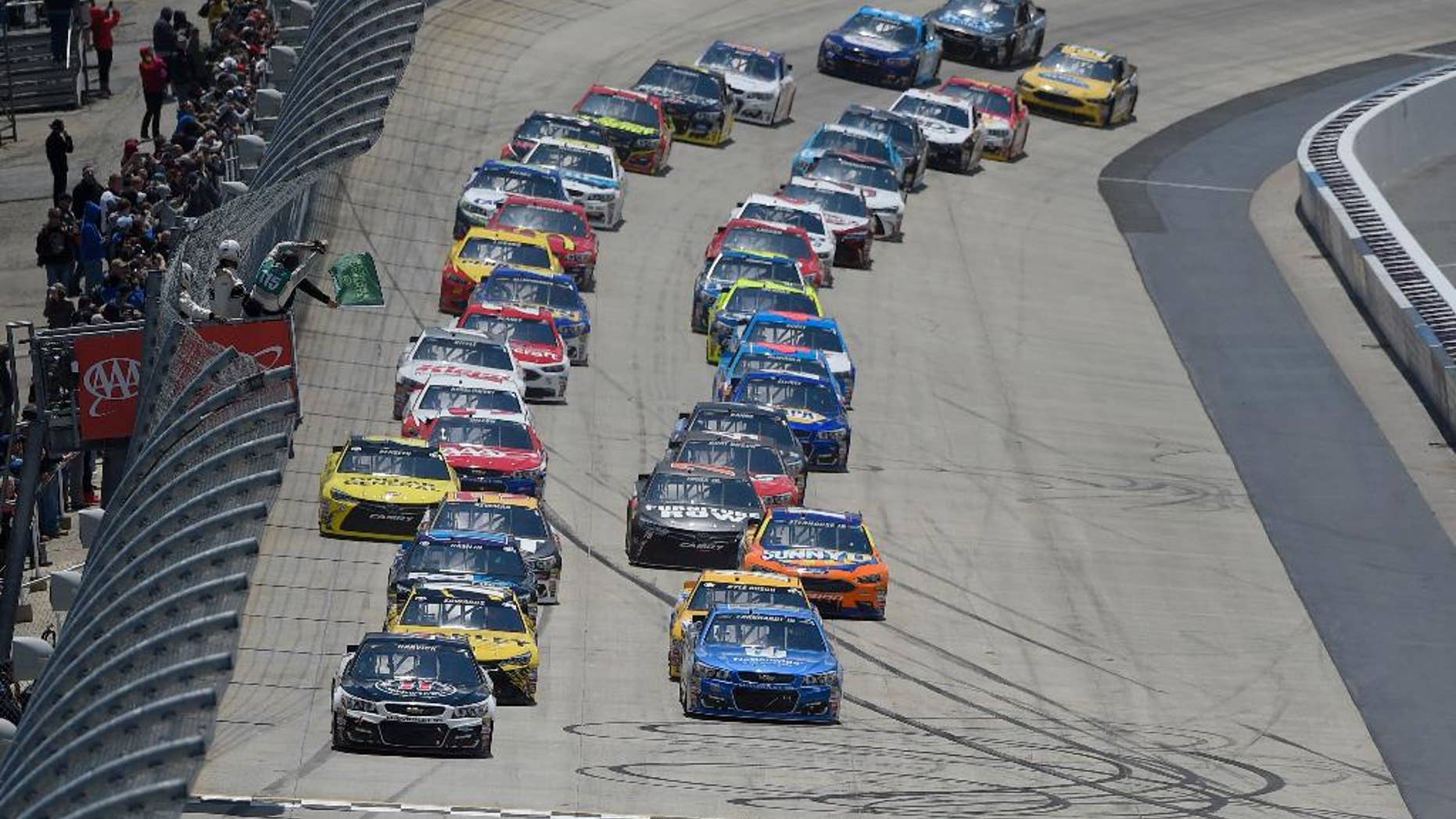 Kevin Harvick, front left, and Dale Earnhardt Jr., front right, lead the field to take the green flag to start the NASCAR Sprint Cup series auto race, Sunday, May 15, 2016, at Dover International Speedway in Dover, Del. (AP Photo/Nick Wass)