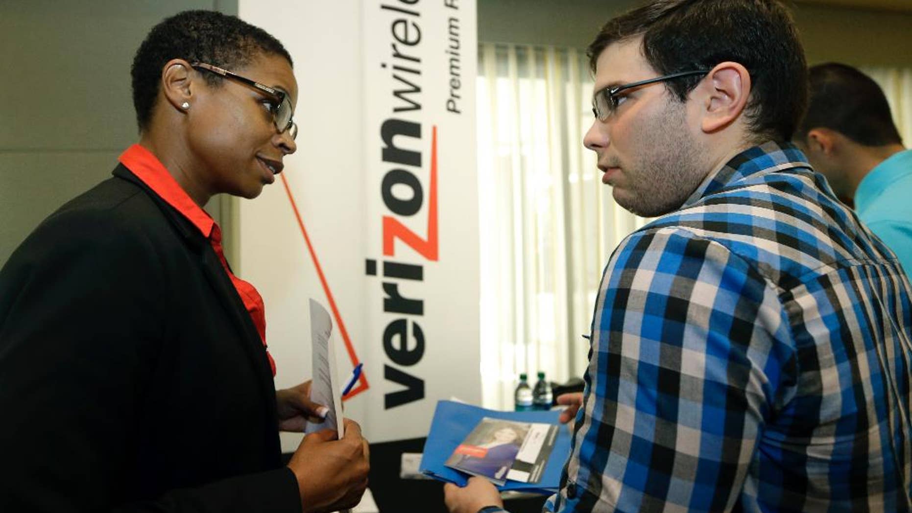 In this July 15, 2015, photo, Sasha Vitalis, left, talks about job opportunities to job seeker Omar Delgado at a job fair in Miami Lakes, Fla. Payroll processor ADP reports how many jobs private employers added in July on Wednesday, Aug. 4, 2015. (AP Photo/Alan Diaz)