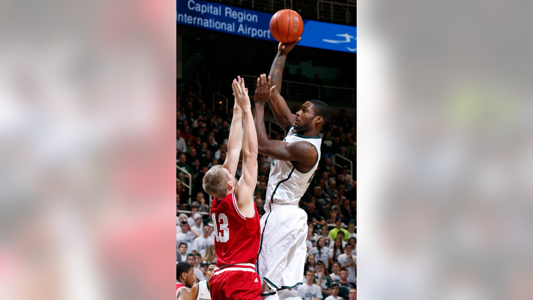 Michigan State's Branden Dawson, right, shoots over Indiana's Austin Etherington (13) during the second half of an NCAA college basketball game, Tuesday, Jan. 21, 2014, in East Lansing, Mich. Michigan State won 71-66. (AP Photo/Al Goldis)