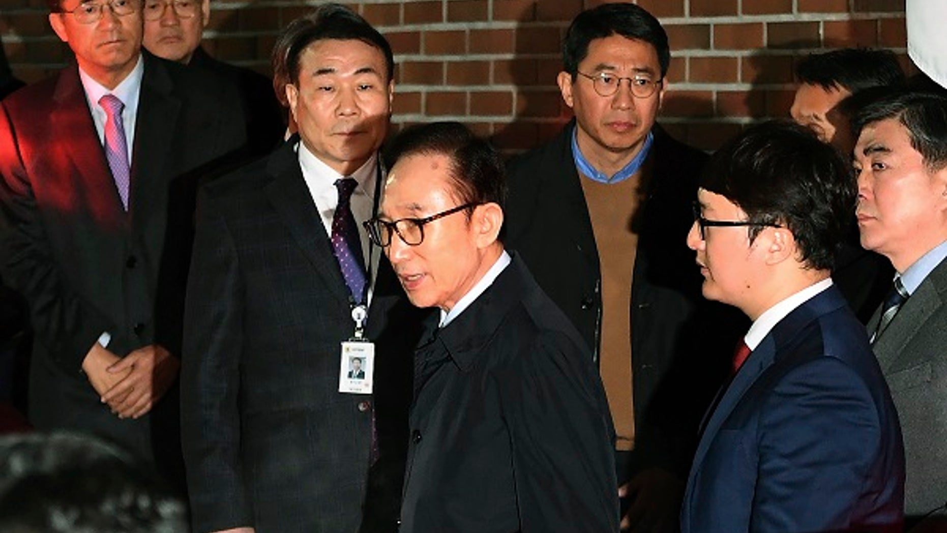 Former South Korean President Lee Myung-bak, centre, gets into a car as he is transferred to a detention centre, at his residence in Seoul early Friday March 23, 2018. A South Korea court issued an arrest warrant for ex-President Lee Myung-bak on corruption charges on Thursday. (Jung Yeon-je/Pool via AP)