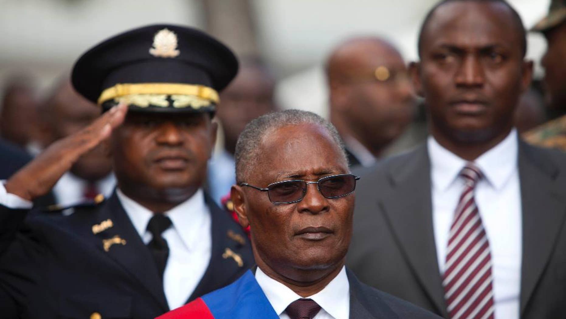 FILE - In this Feb. 14, 2016, file photo, Haiti's provisional President Jocelerme Privert stands for the national anthem after delivering his speech at an installation ceremony, in Port-au-Prince, Haiti. Haiti’s deeply divided lawmakers met at the National Assembly but were unable to make progress toward a vote on the interim president’s mandate which expired two weeks ago. The fruitless session began Tuesday, June 28 and was adjourned early Wednesday. (AP Photo/Dieu Nalio Chery, File)