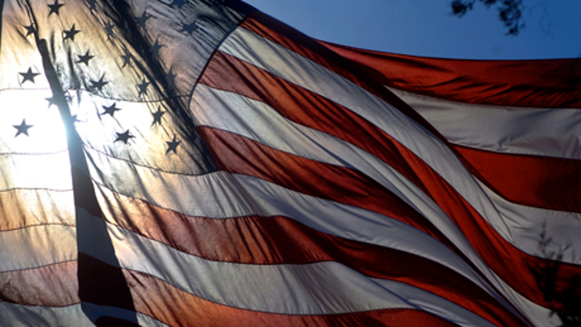 The giant American flag at South Park Cemetery in Roswell, N.M. flaps in a light breeze under a cloudless sky Wednesday, Nov. 10, 2010, the eve of Veterans Day. (AP Photo/Roswell Daily Record, Mark Wilson)