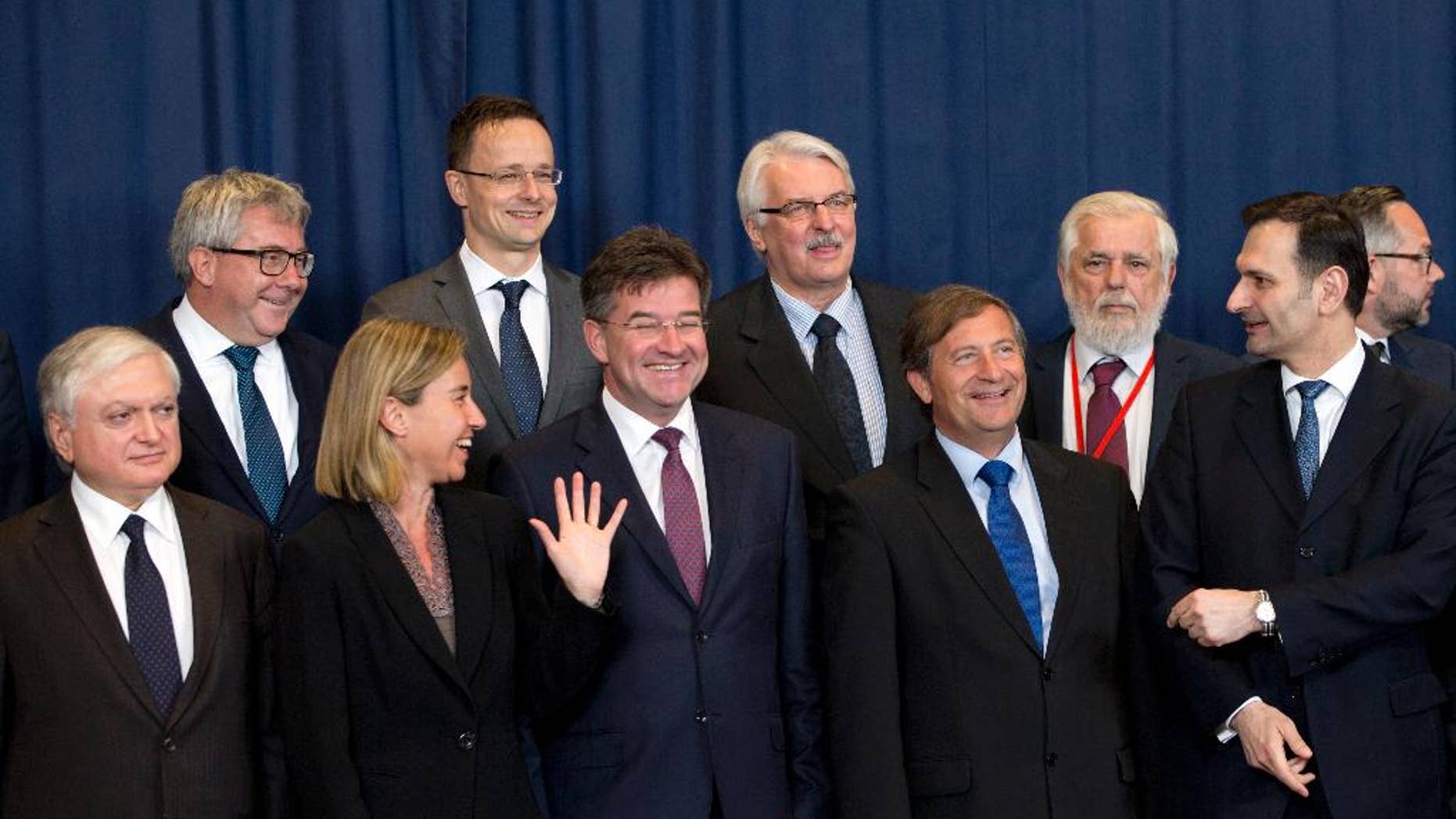 European Union High Representative Federica Mogherini, front second left, speaks with, Slovakian Foreign Minister Miroslav Lajcak, front center, and Slovenian Foreign Minister Karl Erjavec, front second right, prior to a group photo of EU foreign ministers at the EU Council building in Brussels on Monday, May 23, 2016. Libya has given the European Union a green light to begin training its coast guard, as increasing numbers of migrants leave the country bound for Italy. (AP Photo/Virginia Mayo)